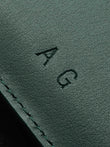 Close up example of colorless debossing with the initials AG.