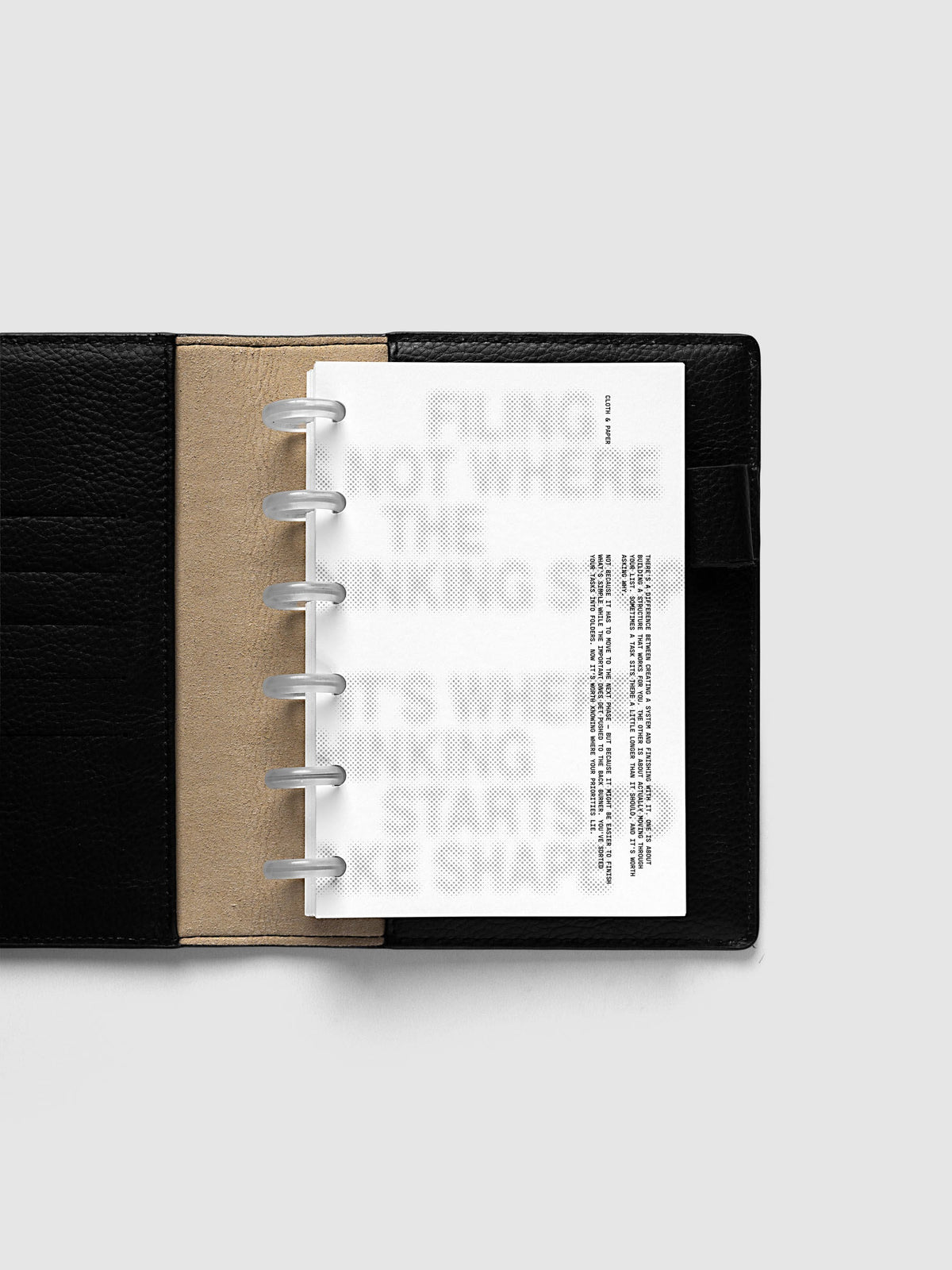 Halftone Planner Dashboard, CP Petite 6-Disc Punch, dashboard on frosted discs in an open black leather planner with a kraft interior panel