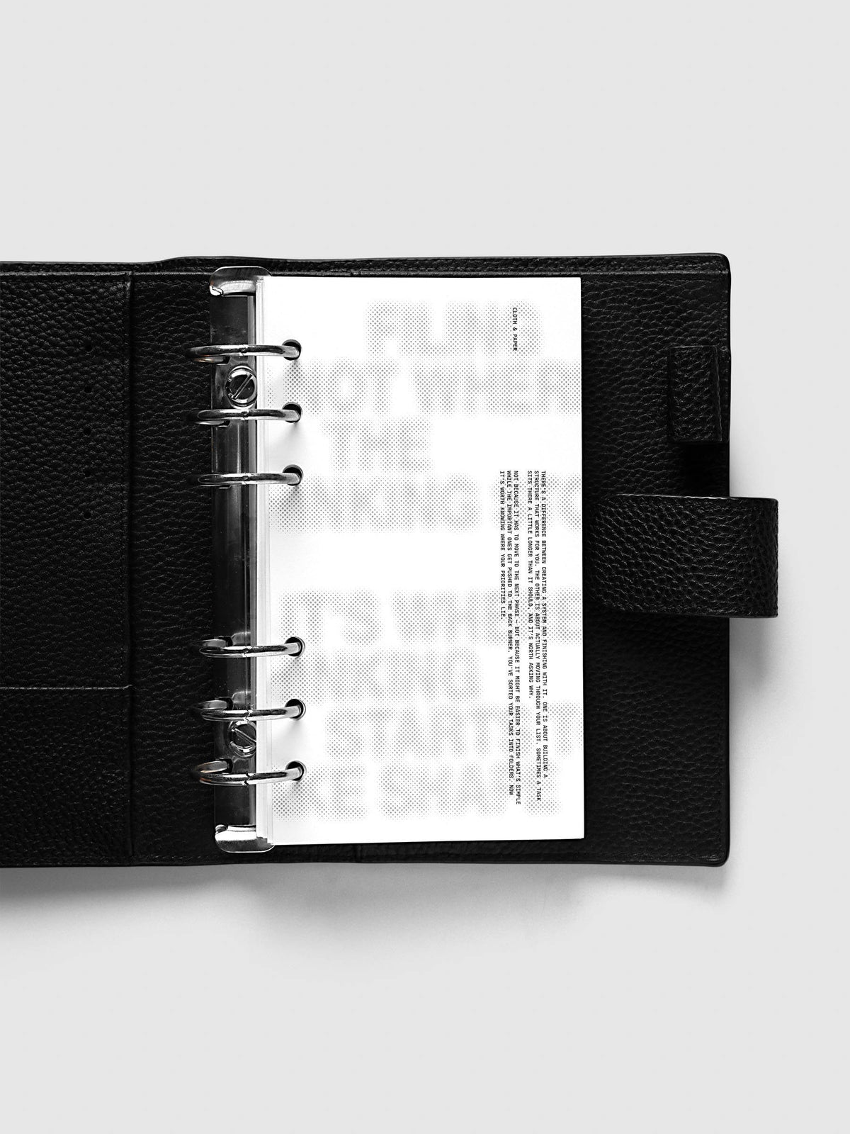Halftone Planner Dashboard, Personal 6-Ring Punch, dashboard on the rings of an open black leather planner, the grey halftone headline across the page