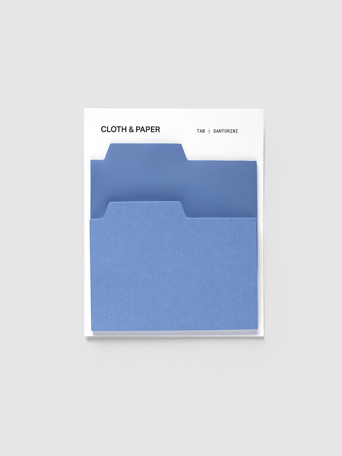Blank Tab Sticky Note Set, Santorini, Cloth and Paper. Set on its backing card, a transparent blue pad behind a matte blue pad with the tabs staggered.