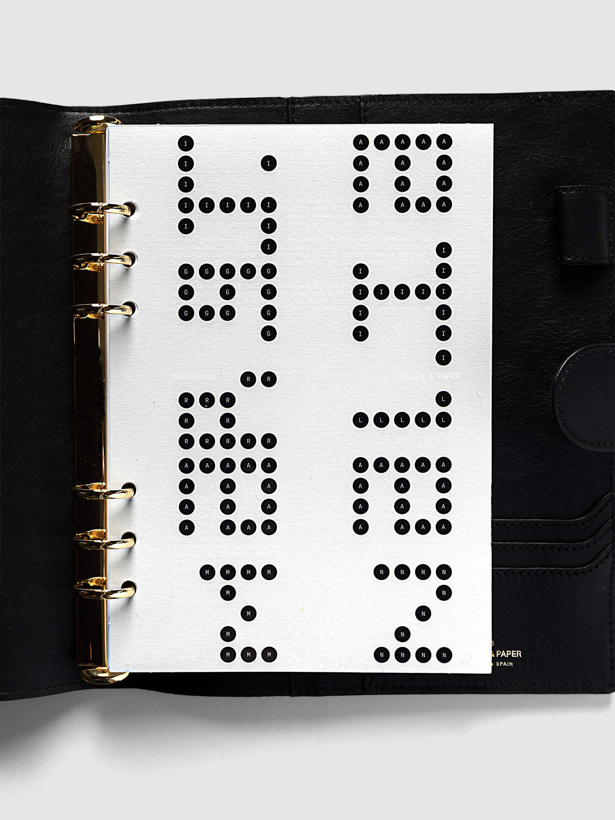 Scantron Dashboard Duo, A5 6-Ring Punch, the dashboard pair on the gold rings of an open black leather planner