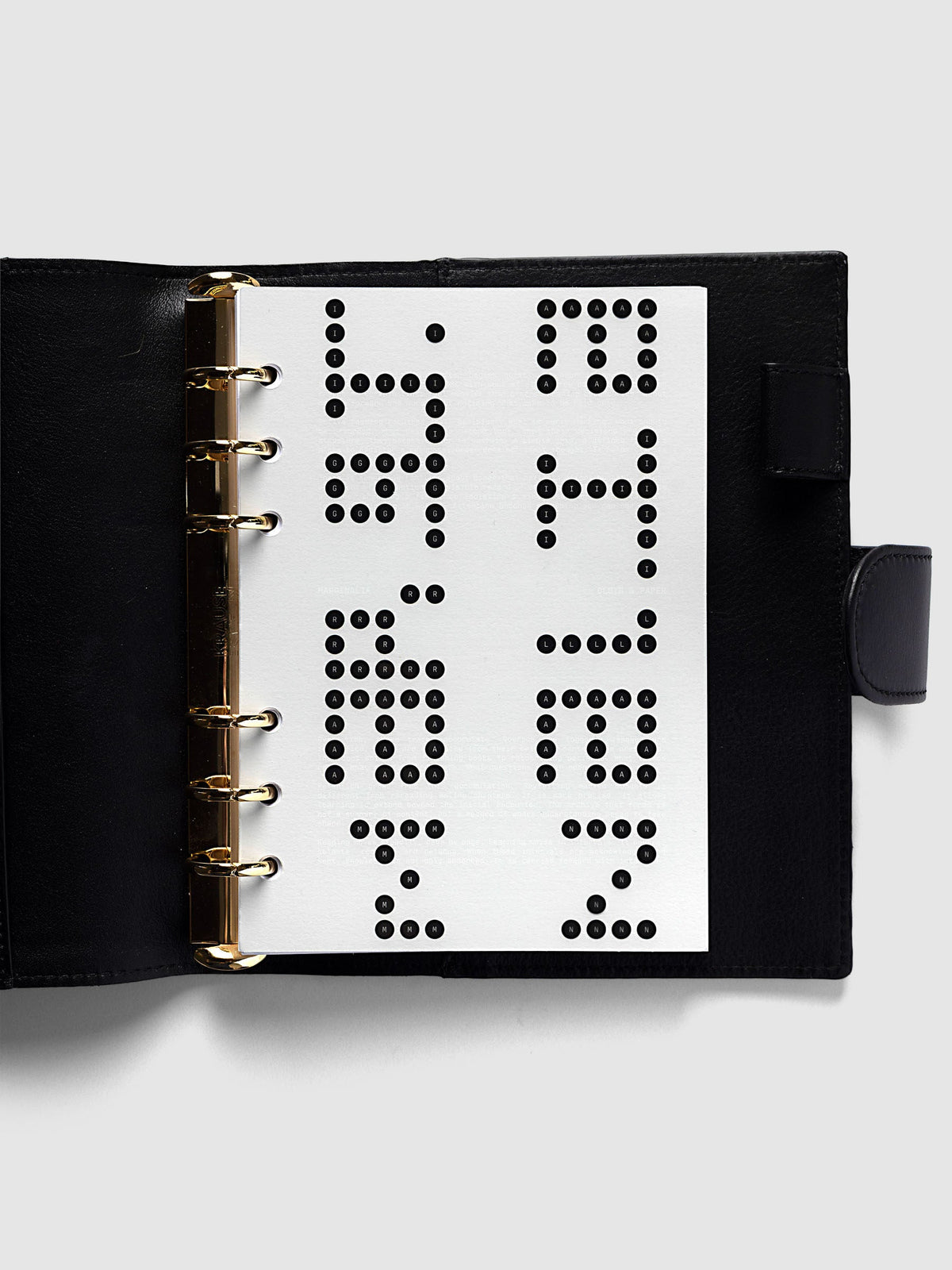 Scantron Dashboard Duo, Personal Wide 6-Ring Punch, the dashboard pair on the rings of an open black leather planner