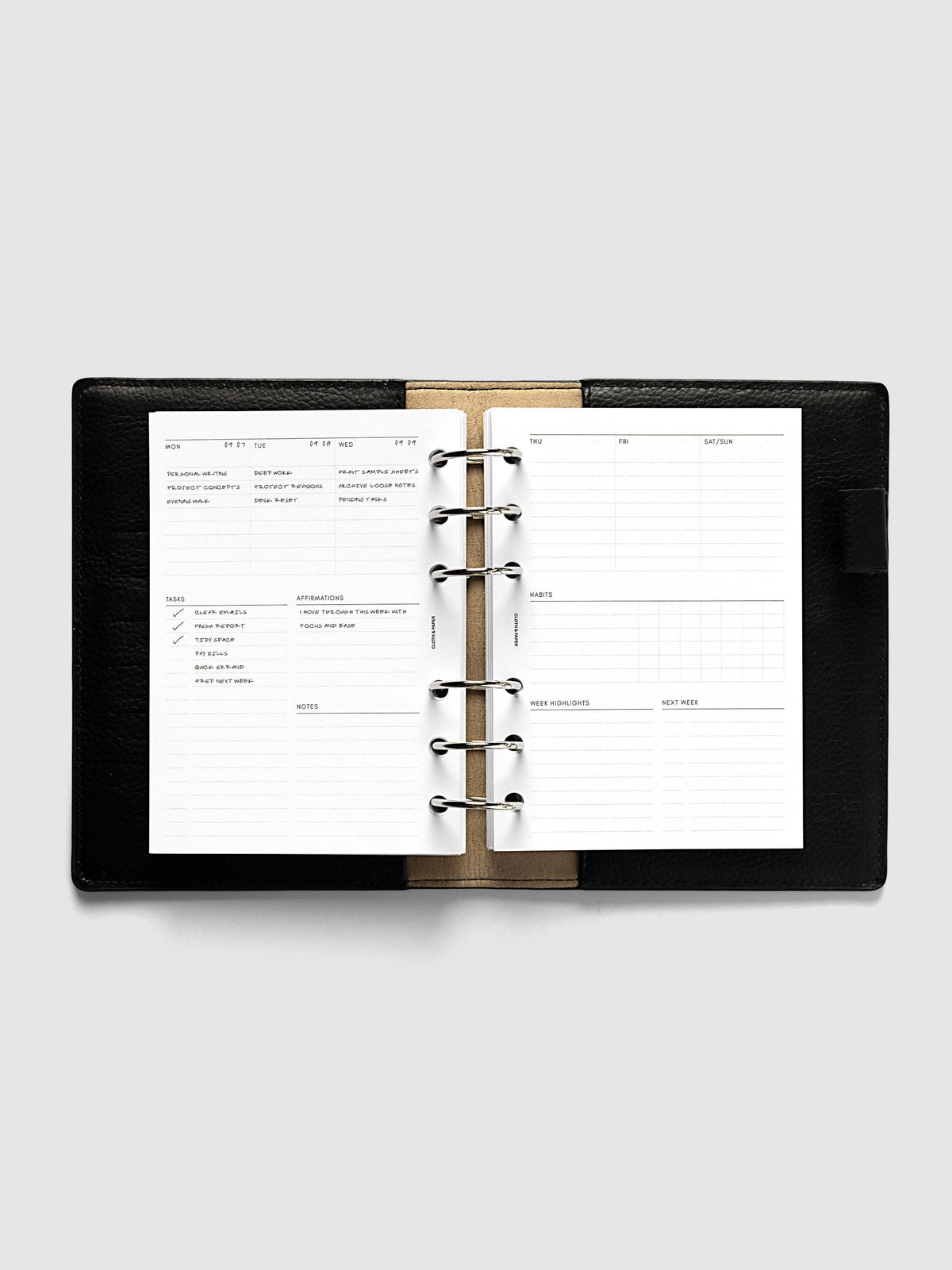Weekly Essentials Planner Inserts, A6 6-Ring Punch, weekly spread open on the rings of a black leather planner