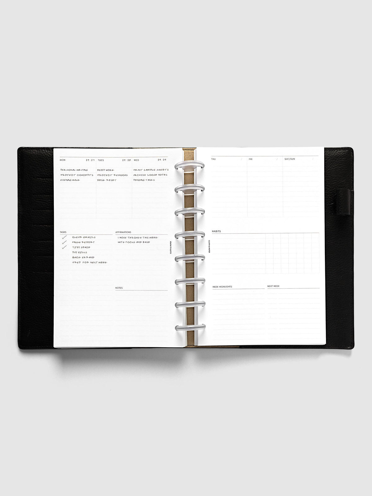 Weekly Essentials Planner Inserts, Half Letter 8-Disc Punch, weekly spread open on frosted discs in a black leather planner