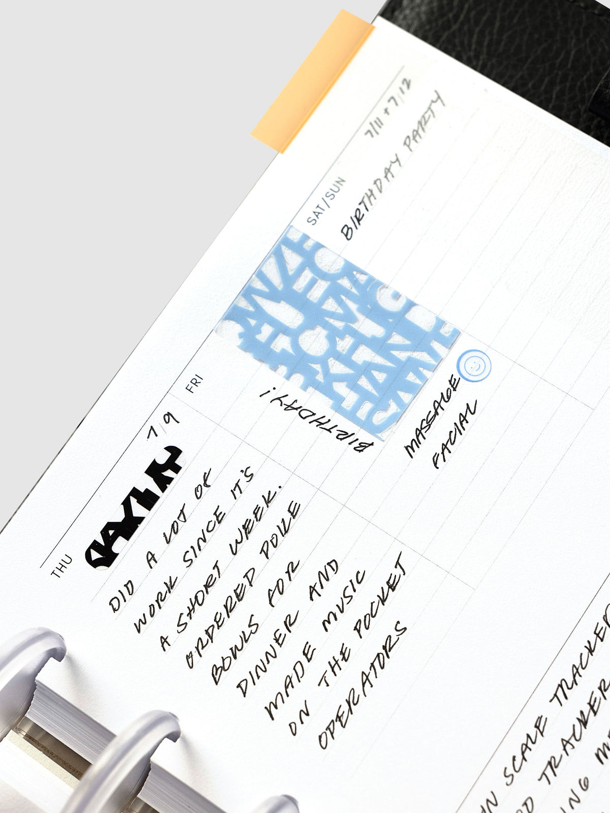 Weekly Essentials Planner Inserts, Half Letter 8-Disc Punch, angled close-up of handwritten daily entries with a blue sticker and tab