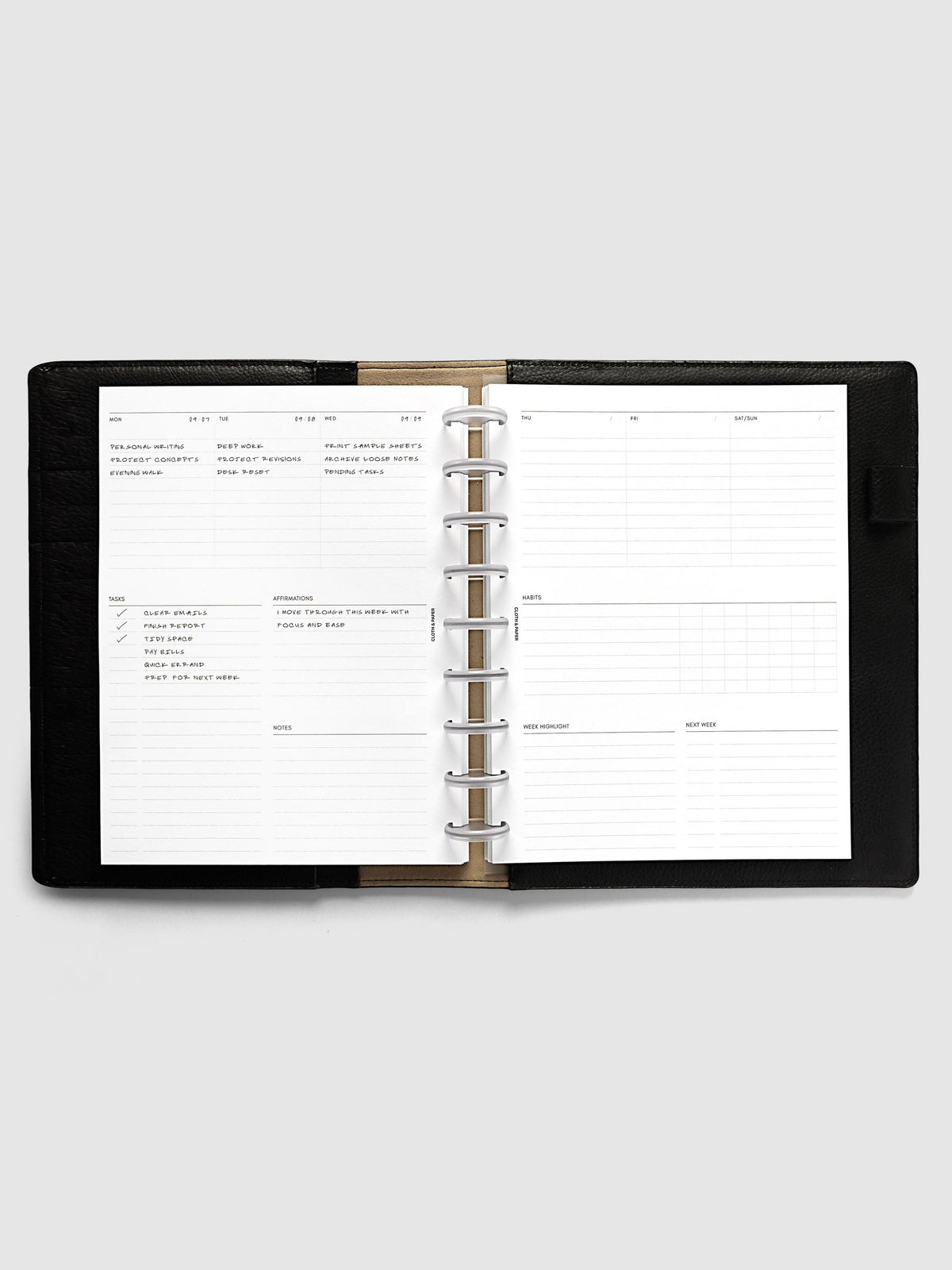 Weekly Essentials Planner Inserts, HP Classic 9-Disc Punch, weekly spread open on frosted discs in a black leather planner