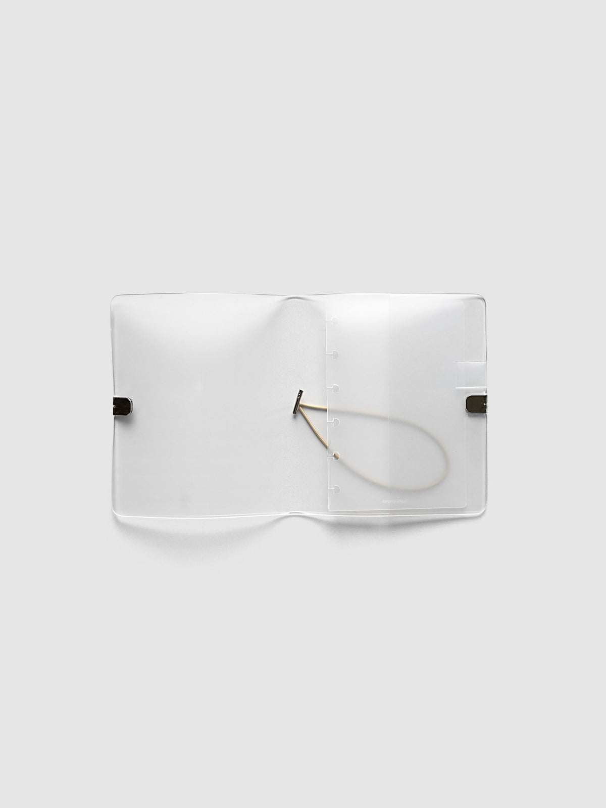 Folio Cover in frosted vinyl, CP Petite (CP Petite 6-Disc Punch), open flat showing the punched disc strip and the beige bungee cord inside
