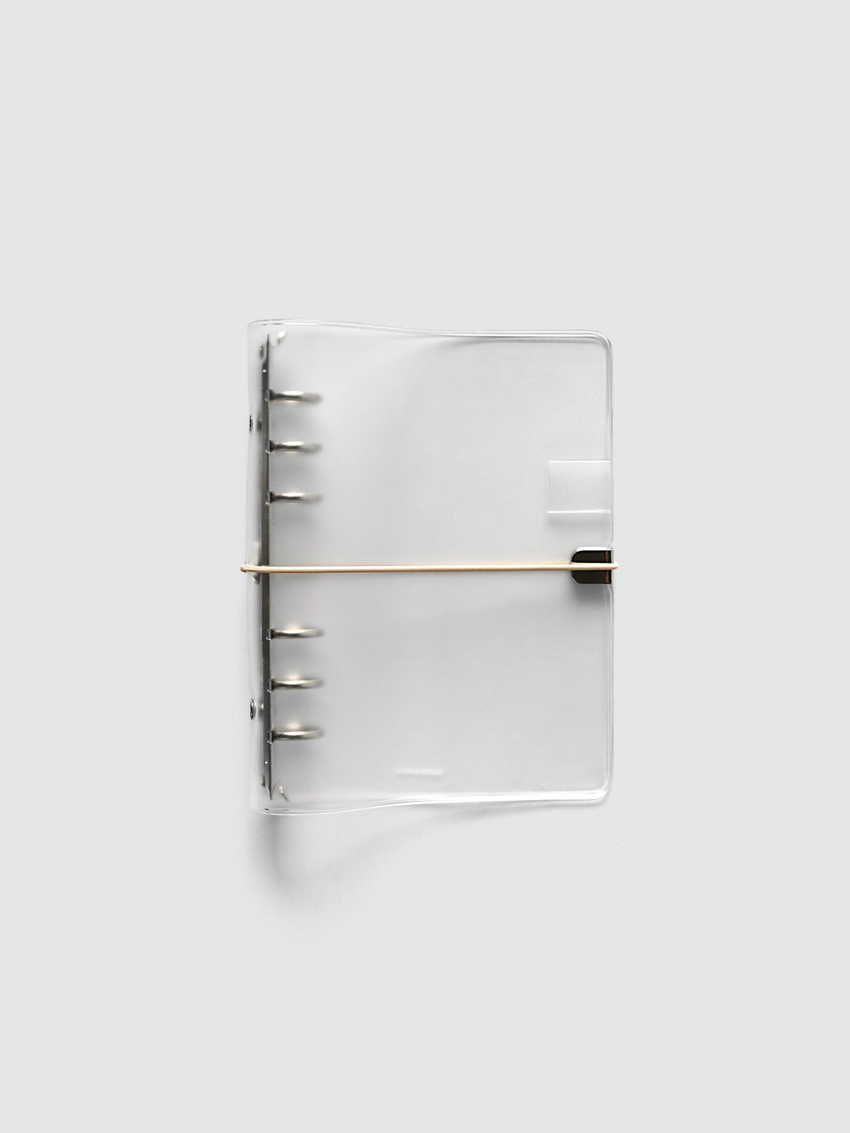 Ring Cover in frosted vinyl, Personal 6-Ring Punch, closed, with the silver six-ring mechanism at the spine and a beige bungee cord hooked to a silver metal clip