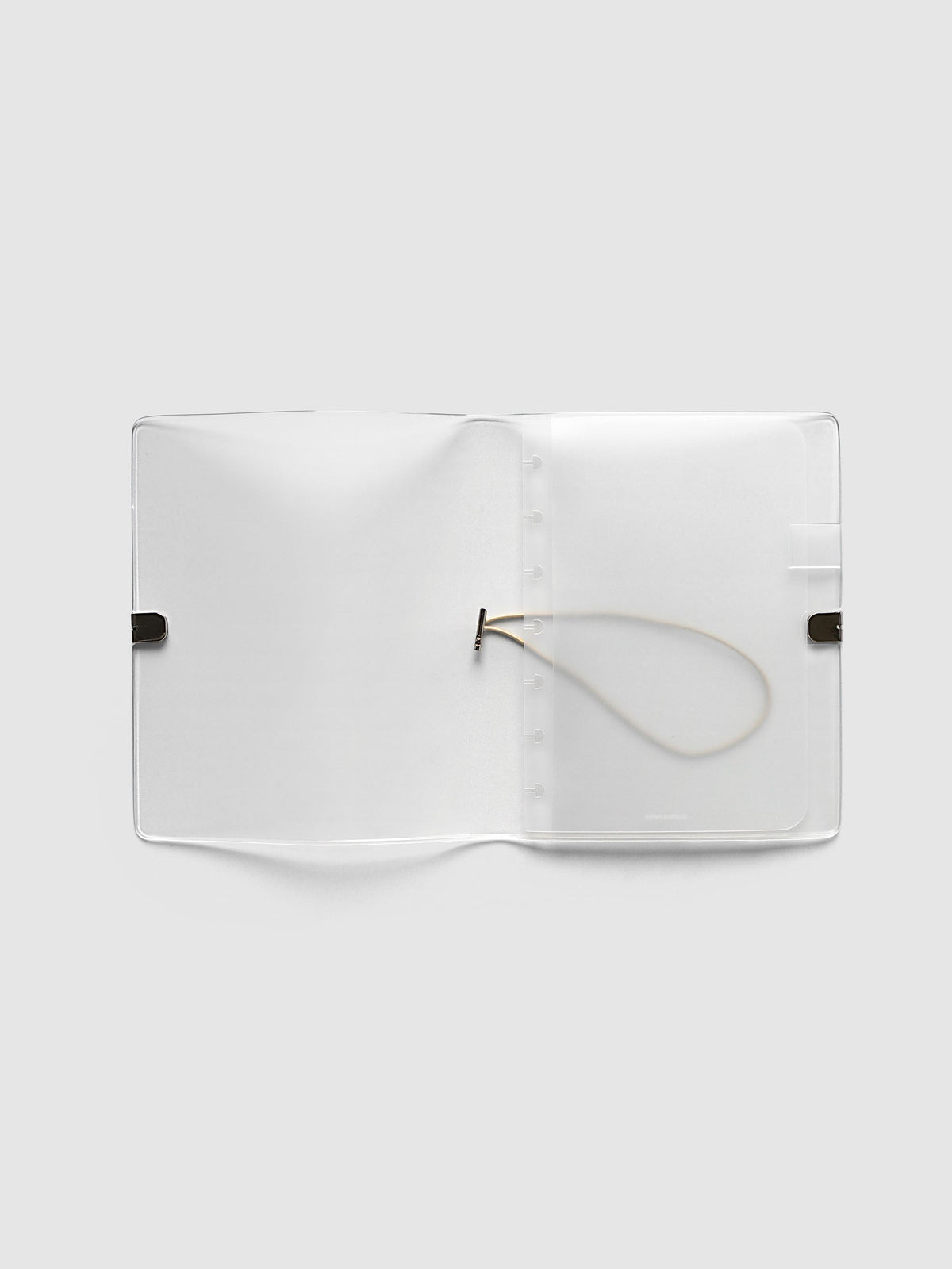 Folio Cover in frosted vinyl, Small (HP Mini 7-Disc Punch), open flat showing the punched disc strip and the beige bungee cord inside