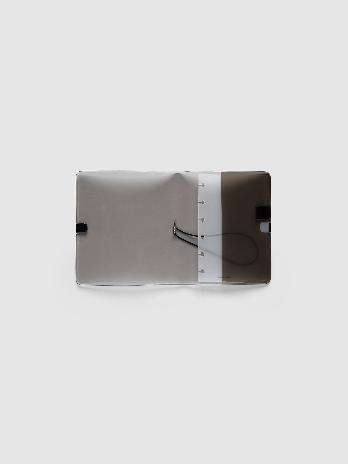 Folio Cover in black tinted vinyl, CP Petite (CP Petite 6-Disc Punch), open flat showing the punched disc strip and the black bungee cord inside