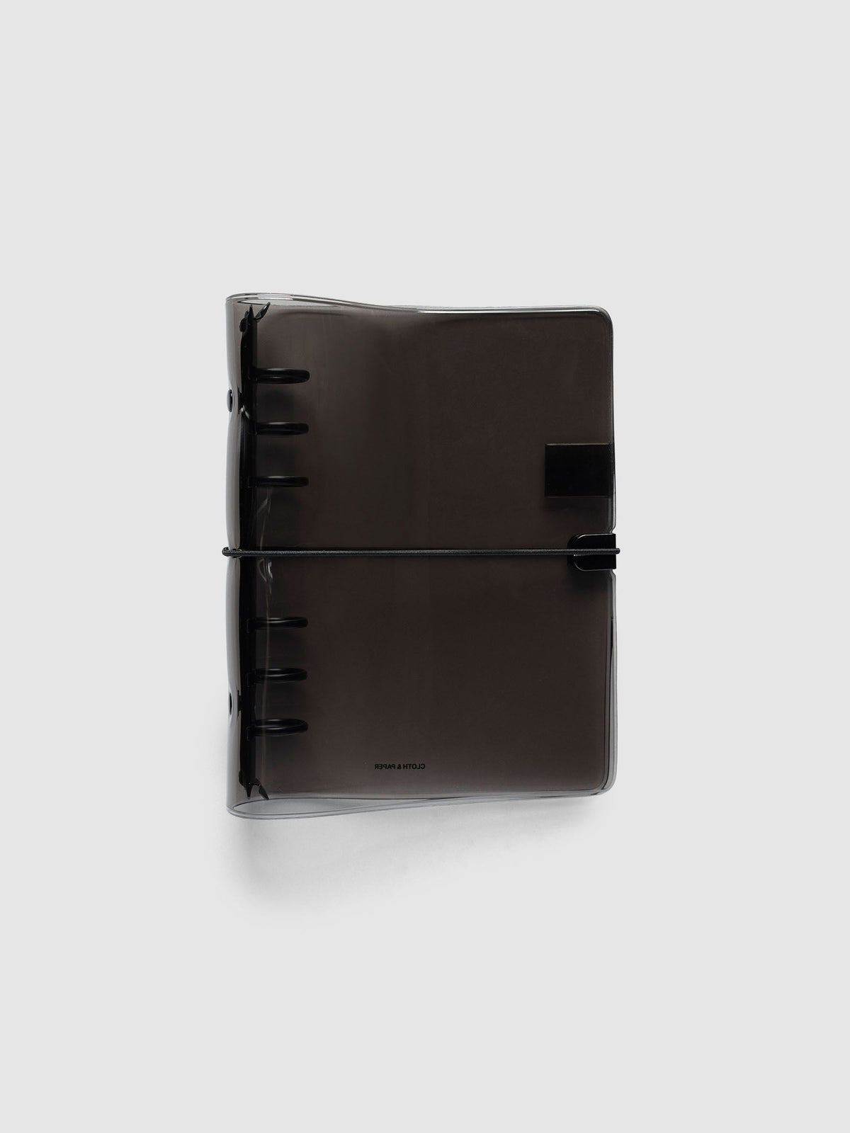 Ring Cover in black tinted vinyl, Personal 6-Ring Punch, closed, with the black six-ring mechanism at the spine and a black bungee cord hooked to a black clip