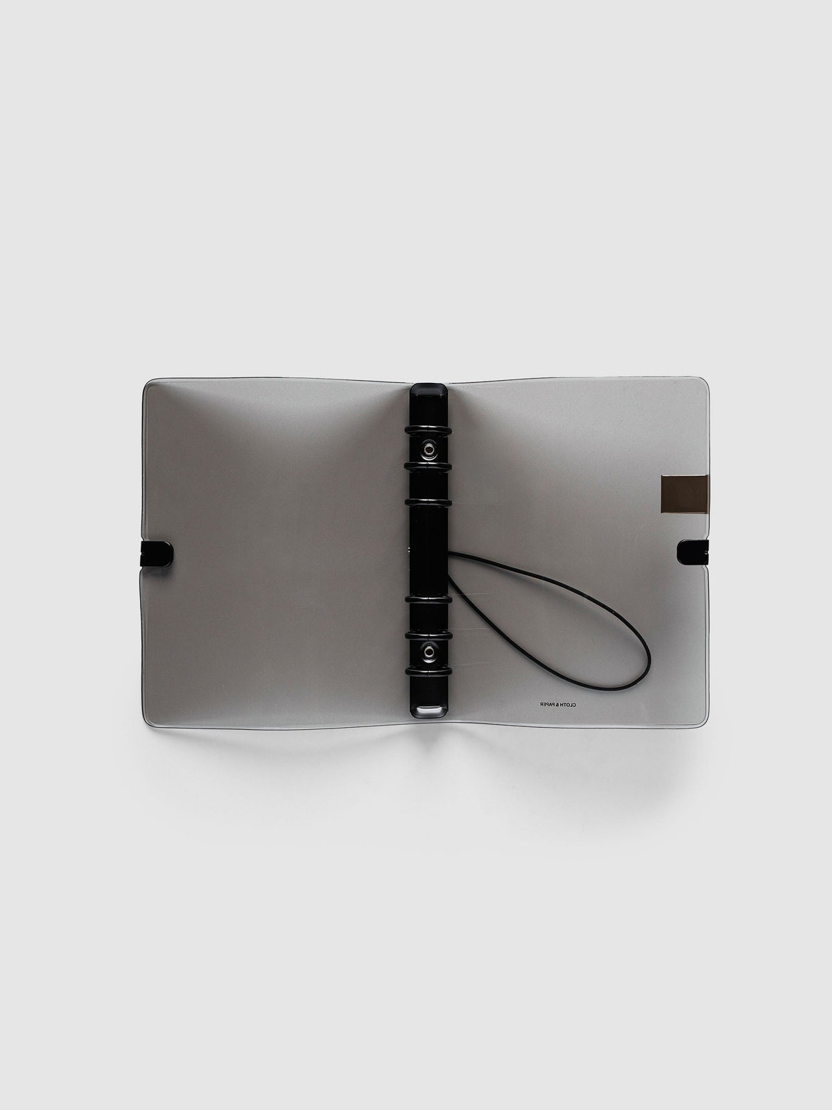 Ring Cover in black tinted vinyl, Personal 6-Ring Punch, open flat showing the black six-ring mechanism, the black bungee cord and the printed logo