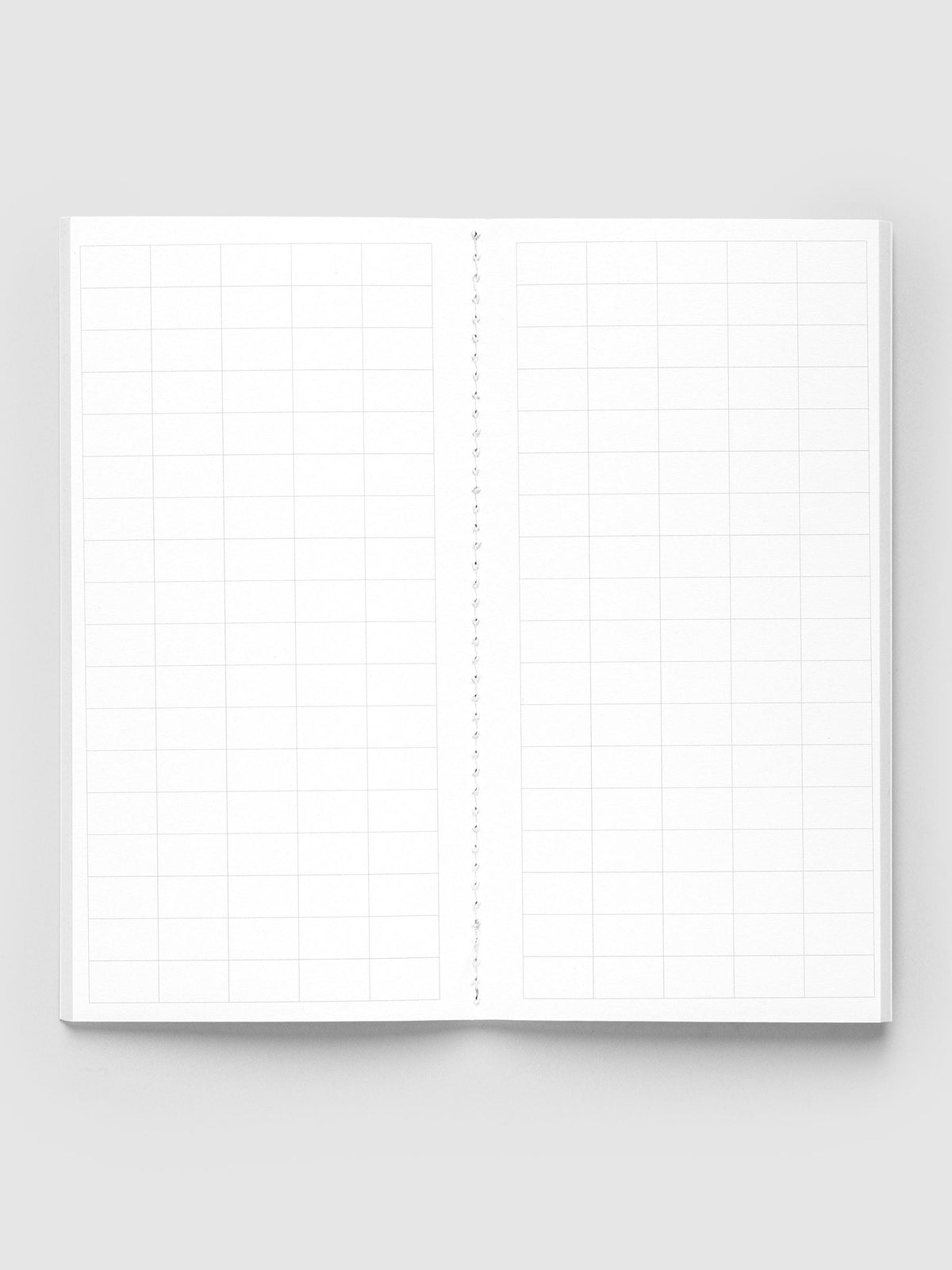 Tangent A5 Slim Travel Notebook open flat to a two-page spread of large graph grid with a stitched spine
