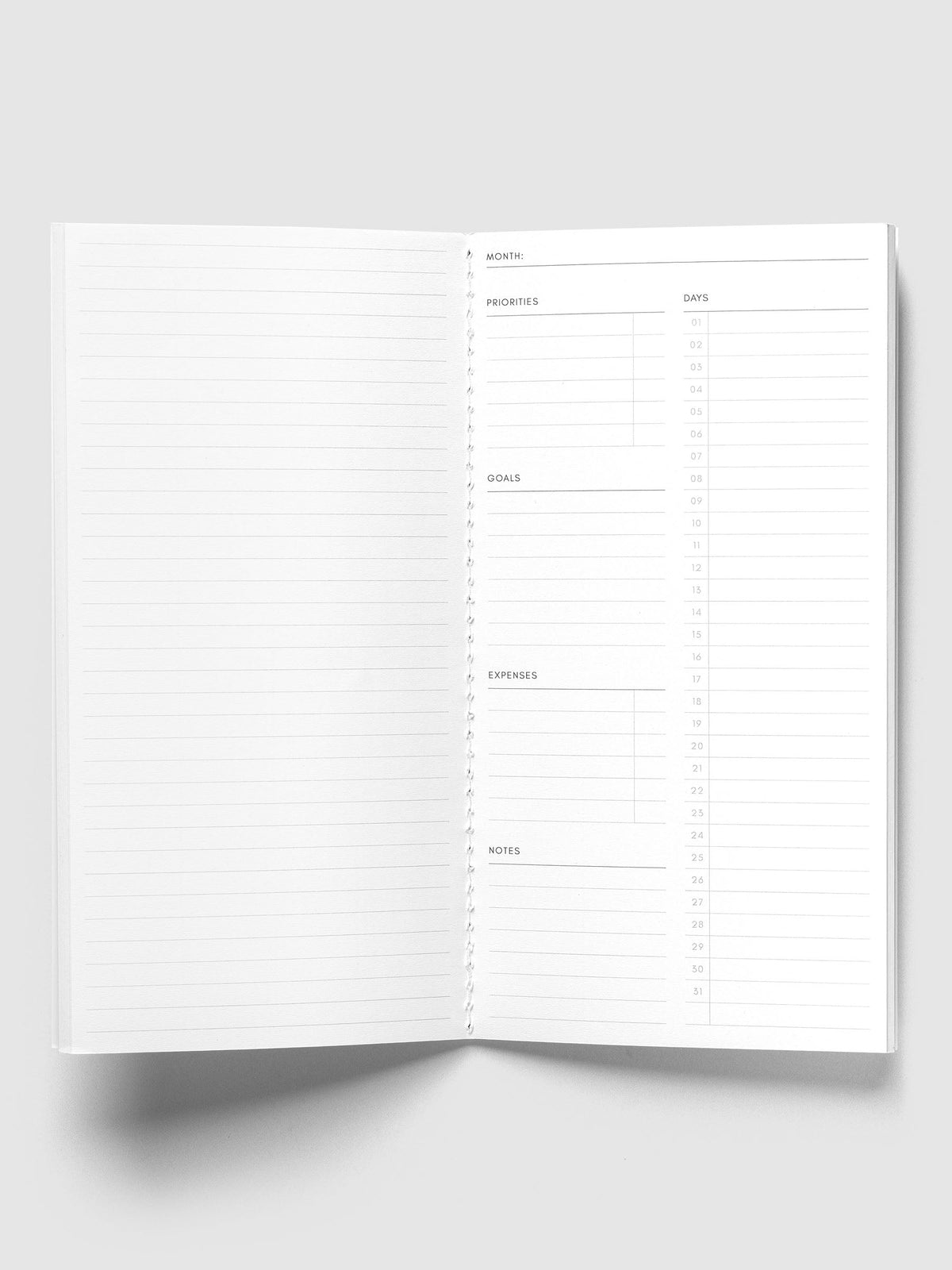 Monthly Overview A5 Slim open to a lined left page and a monthly overview page with priorities, goals, expenses, notes and days 01 to 31