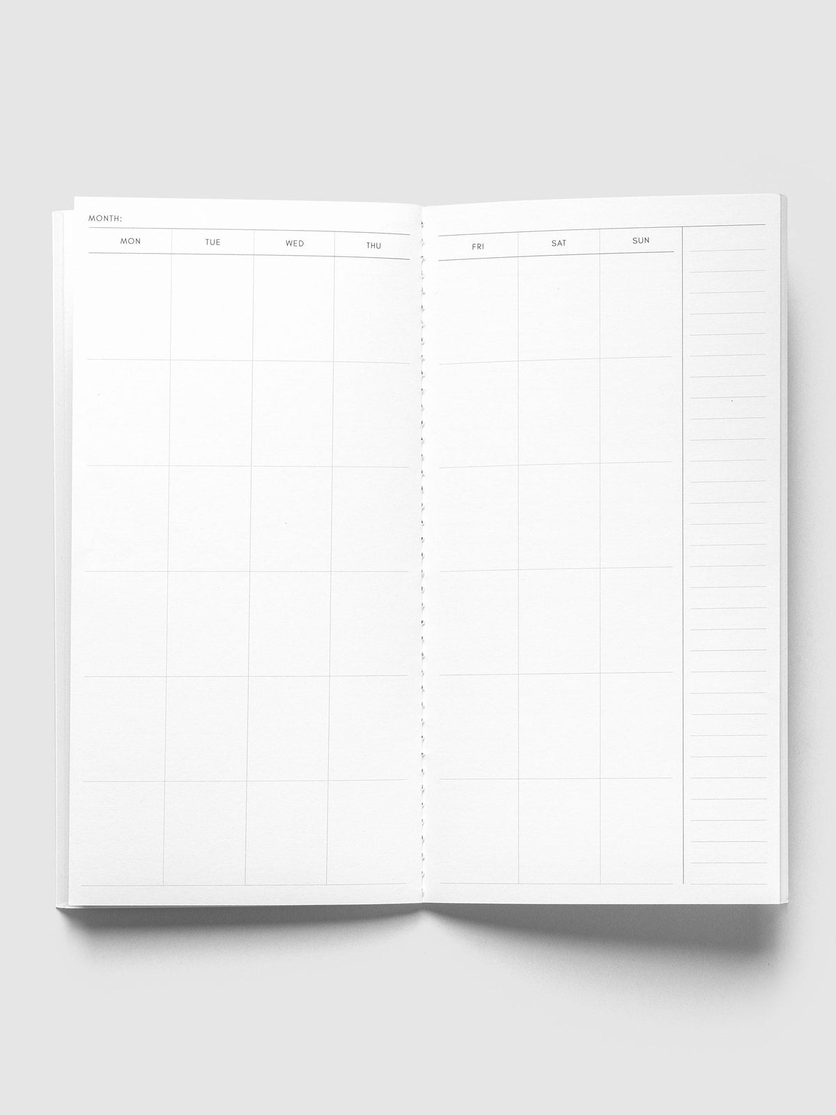 Monthly Overview A5 Slim open to an undated Monday to Sunday month calendar spread with a lined notes column