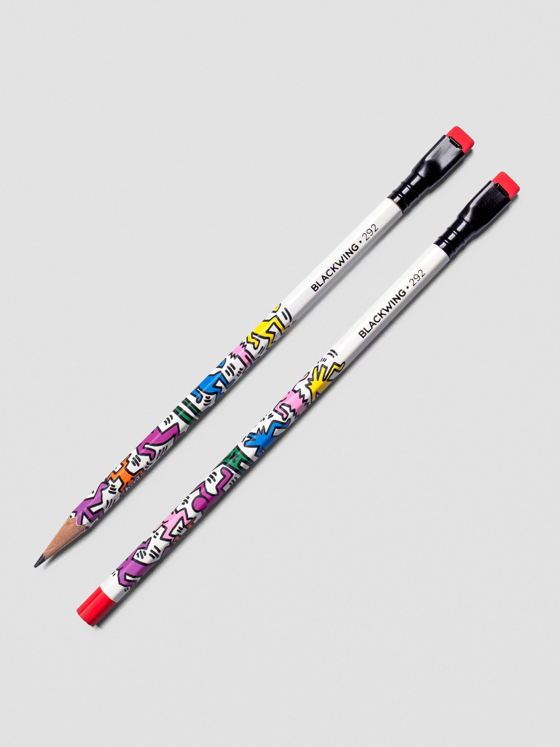 Two pencils from the Blackwing Pencil Set Vol 292 featuring work from Keith Haring; one is shown sharpened, one unsharpened.