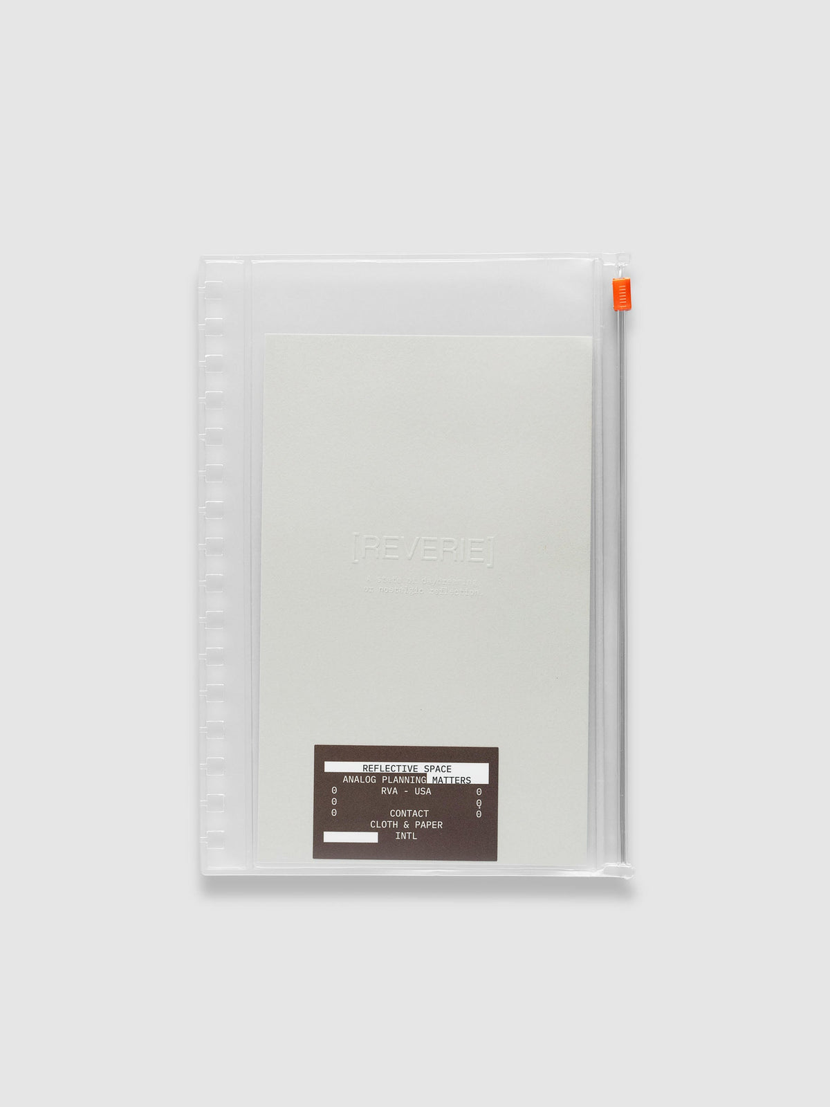 Clear zippered pouch with an orange zipper pull, pre-punched for A5 Spiral notebooks, holding a light grey embossed paper dashboard and a brown sticker. Shown in size A5 Spiral.