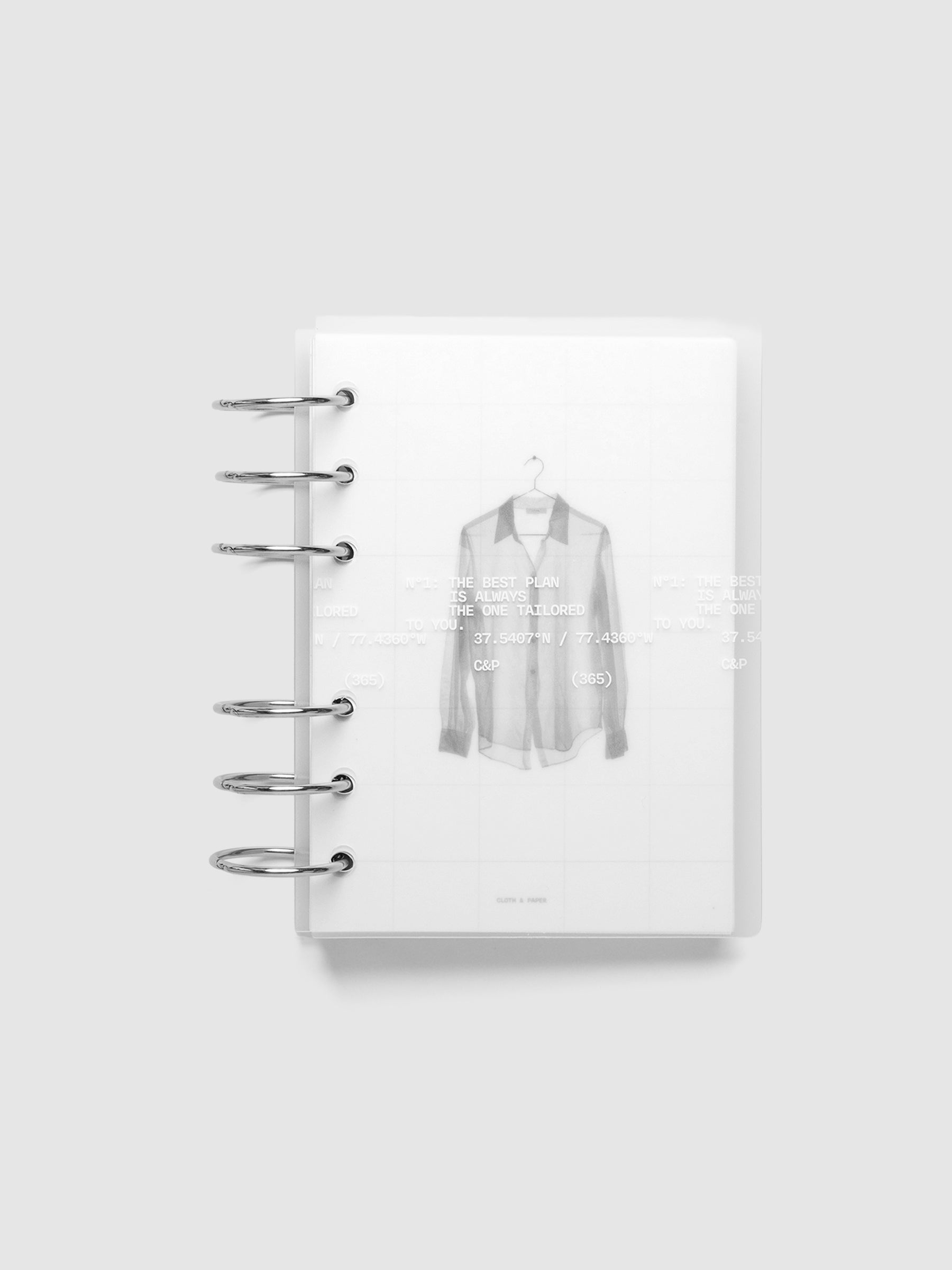 Transparent planner cover set with white printed text design and accompanying black and white dashboard with an image of a tailored shirt on a hanger. Shown ring bound in size A6.
