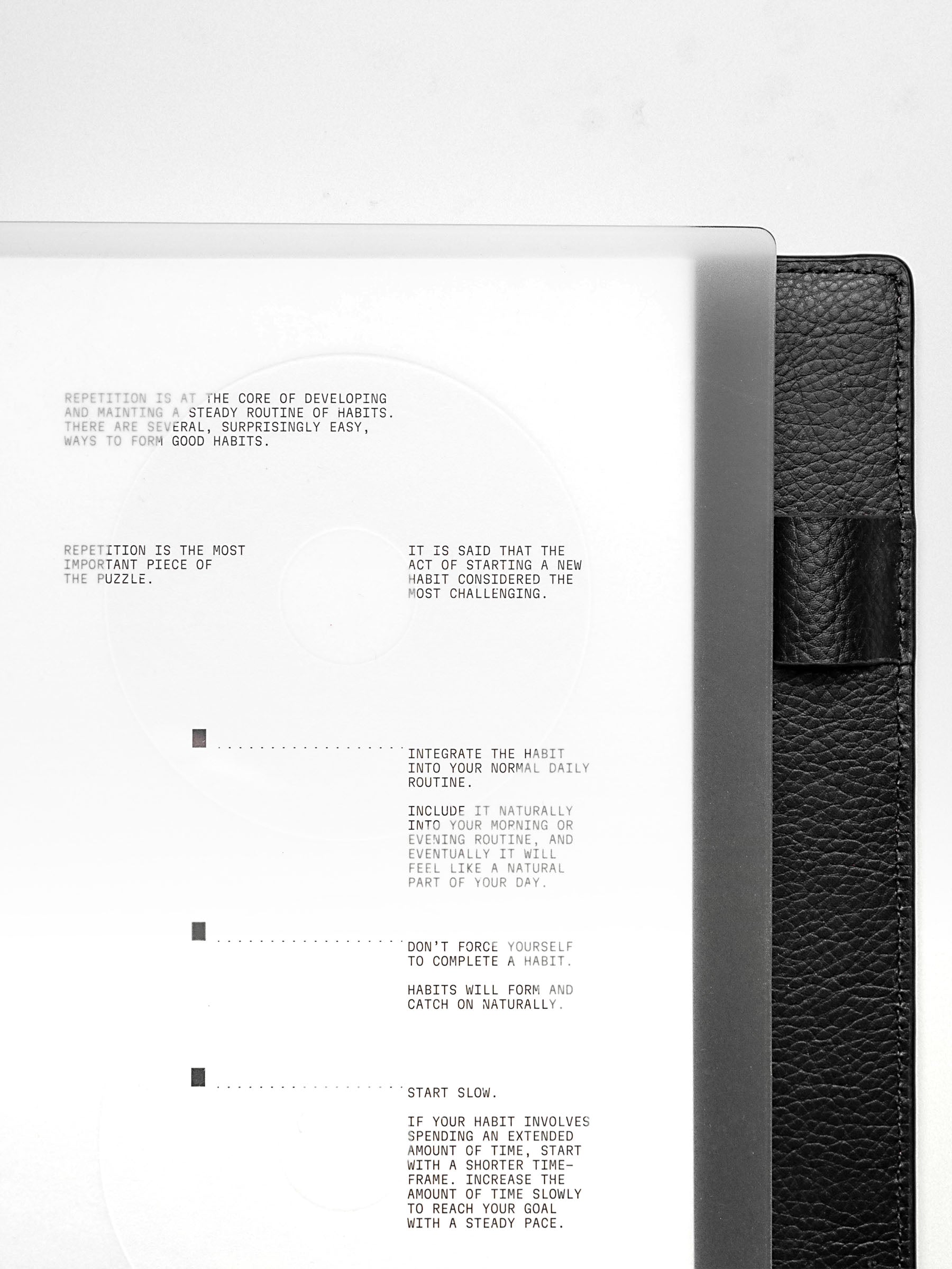 Close up view of a clear planner cover and white paper dashboard with black printed text design.