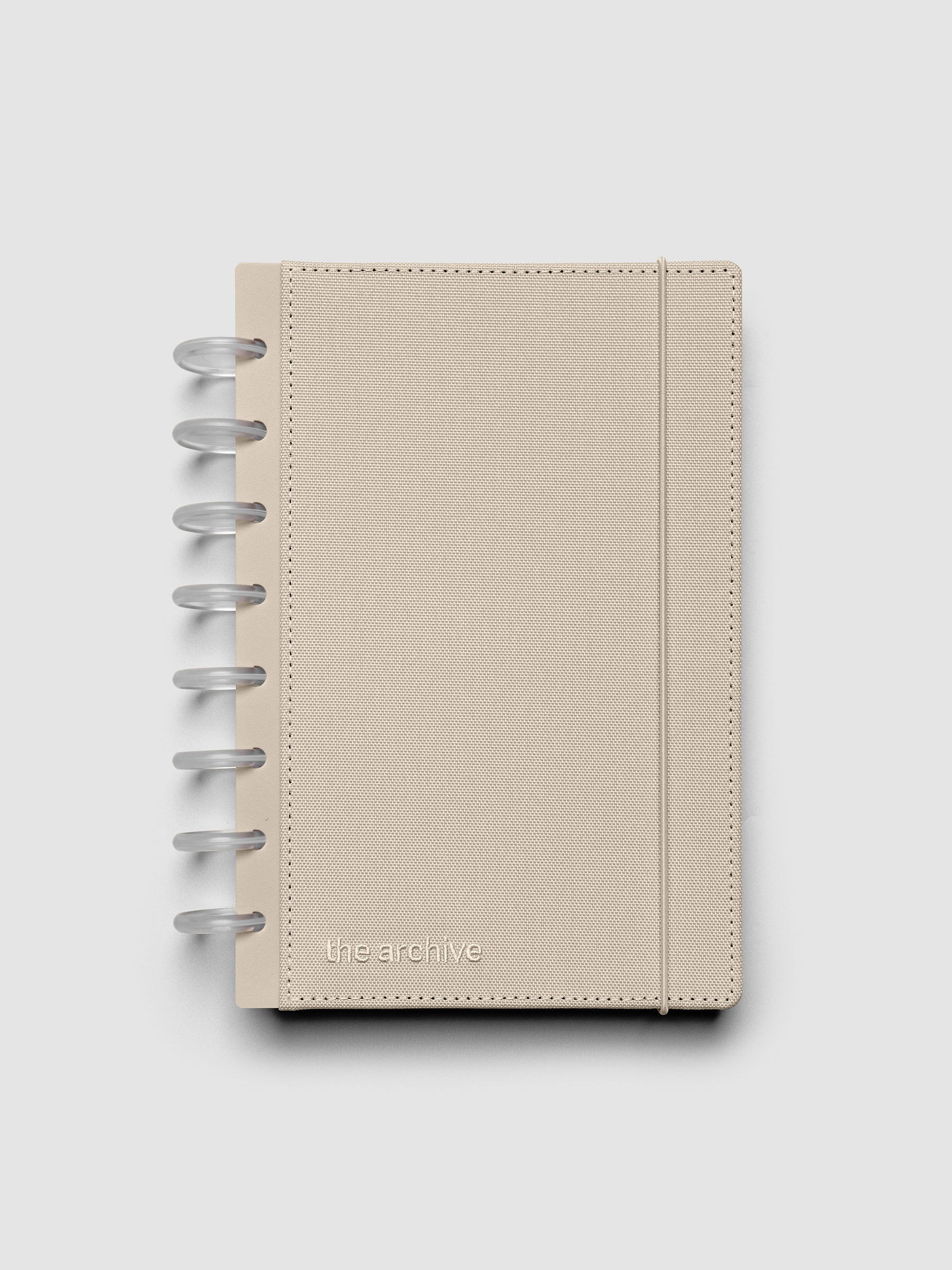 Half Letter discbound planner with a beige bookcloth cover against a grey background.