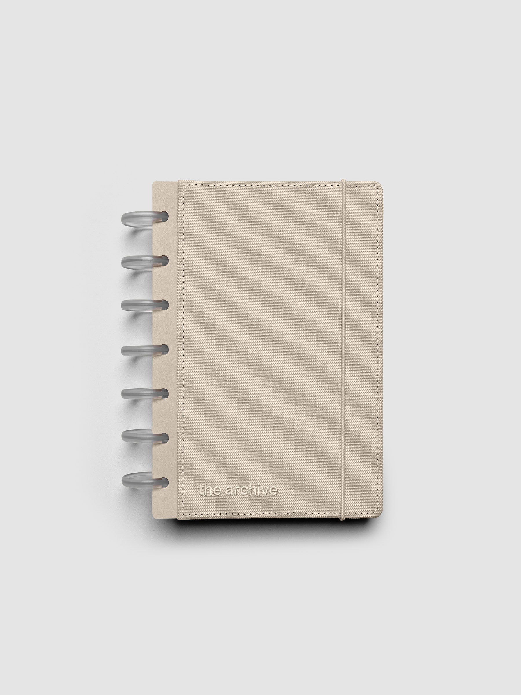 HP Mini discbound planner with a beige bookcloth cover against a grey background.