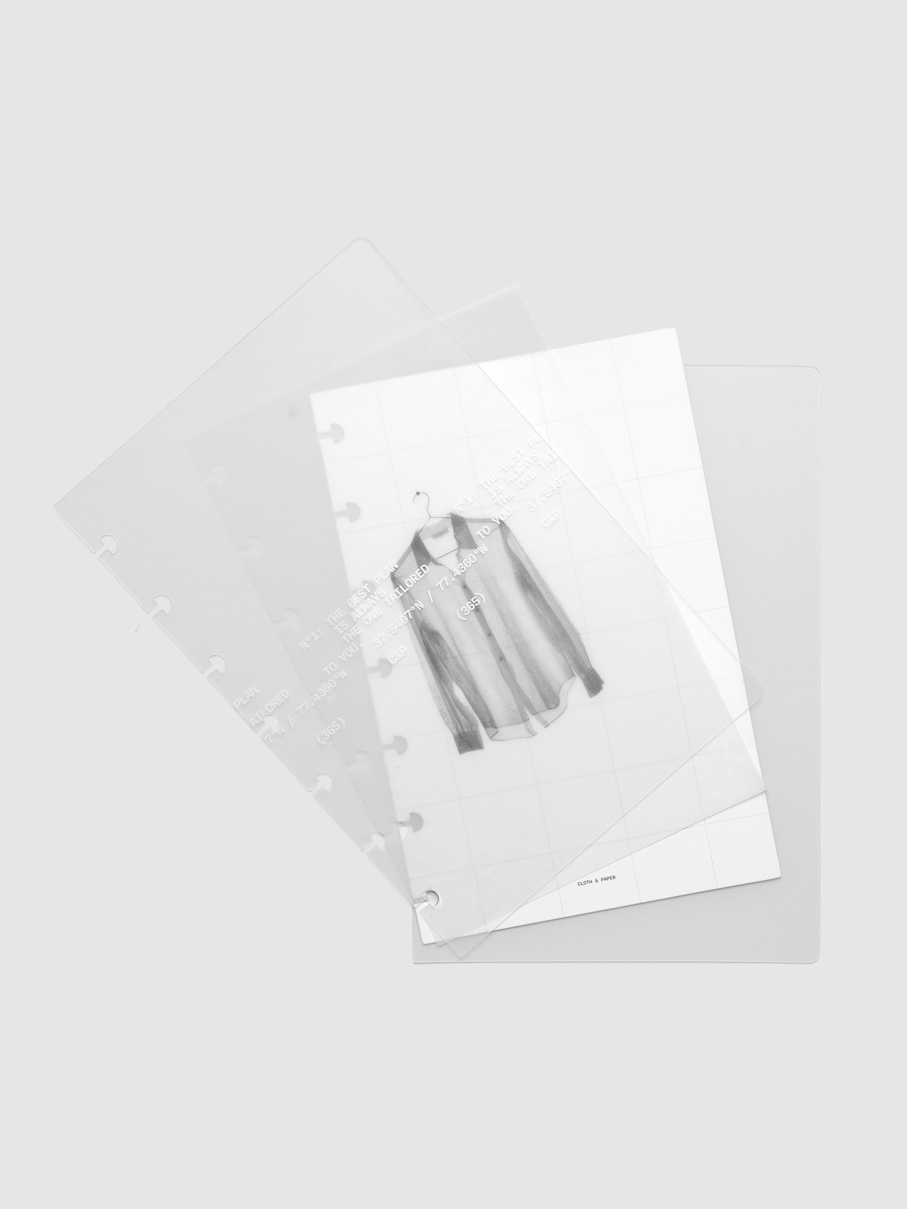 Transparent planner cover set with white printed text design and accompanying black and white dashboard with an image of a tailored shirt on a hanger shown offset. Pre-punched for discbound planners shown in size HP Mini.
