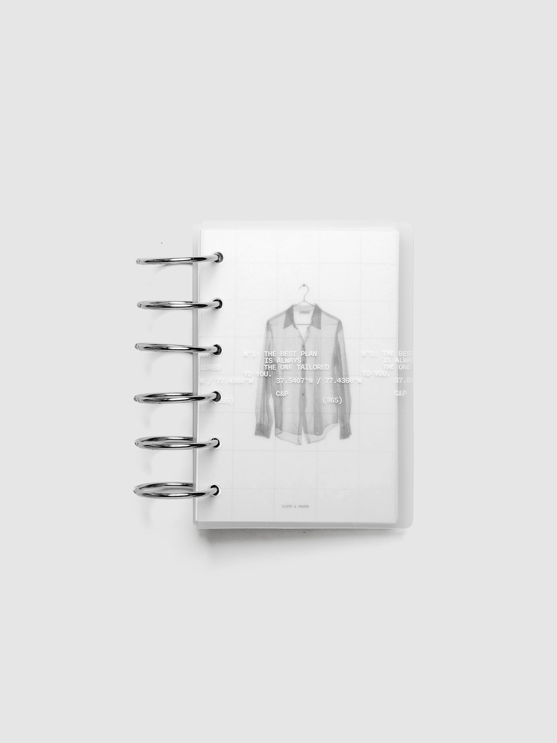 Transparent planner cover set with white printed text design and accompanying black and white dashboard with an image of a tailored shirt on a hanger. Shown ring bound in size Pocket.