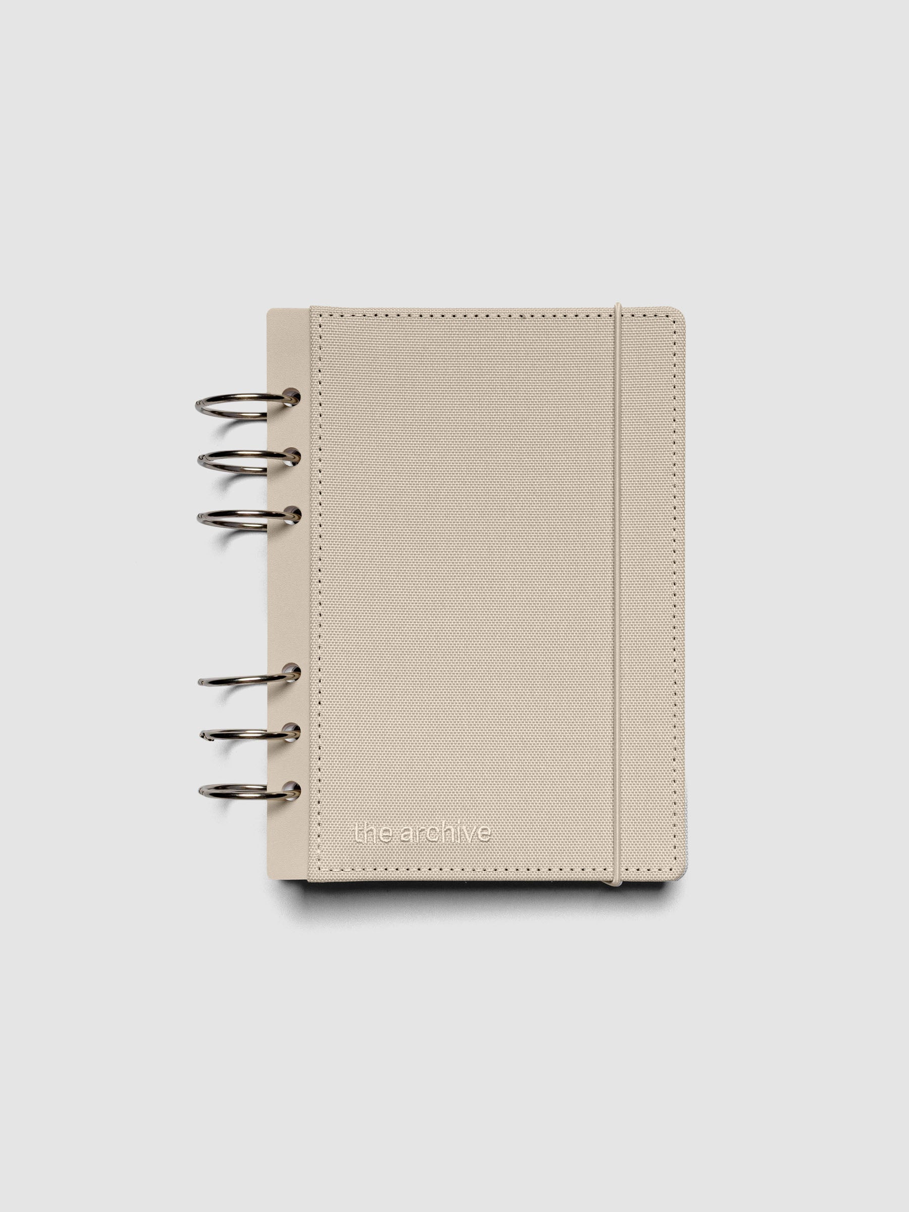 Personal Wide ring bound planner with a beige bookcloth cover against a grey background.