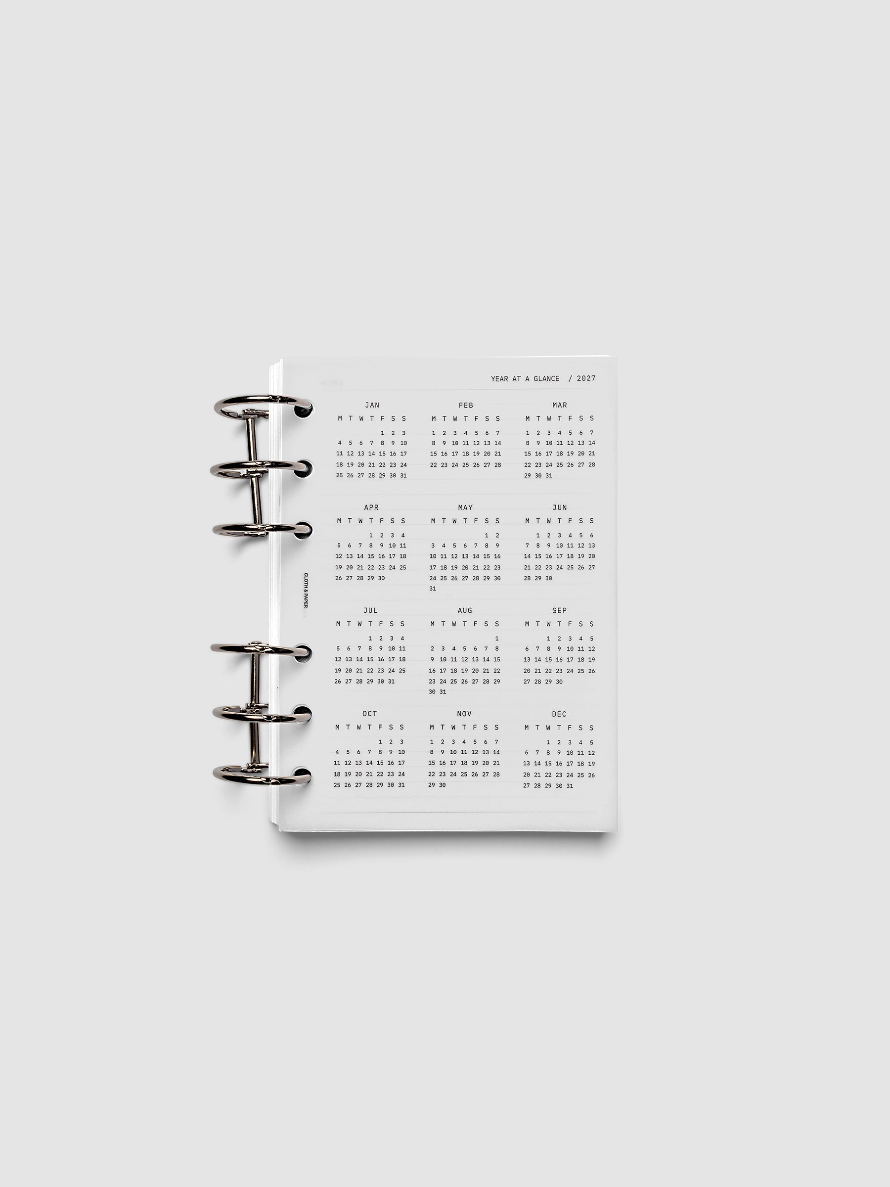 2027 Year At A Glance Dashboard Monday Start, A6 6-Ring Punch, translucent vellum year-at-a-glance calendar shown inside a planner