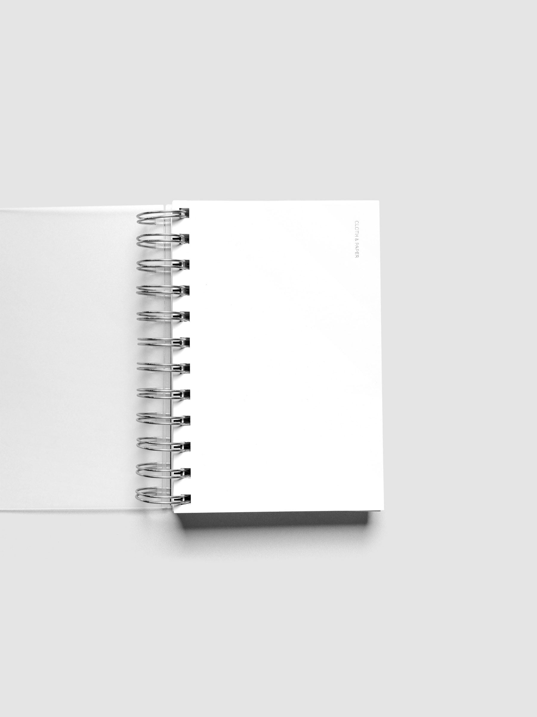 Spiral Notebook dashboard in the color Le Blanc shown in size CP Petite inside a notebook.