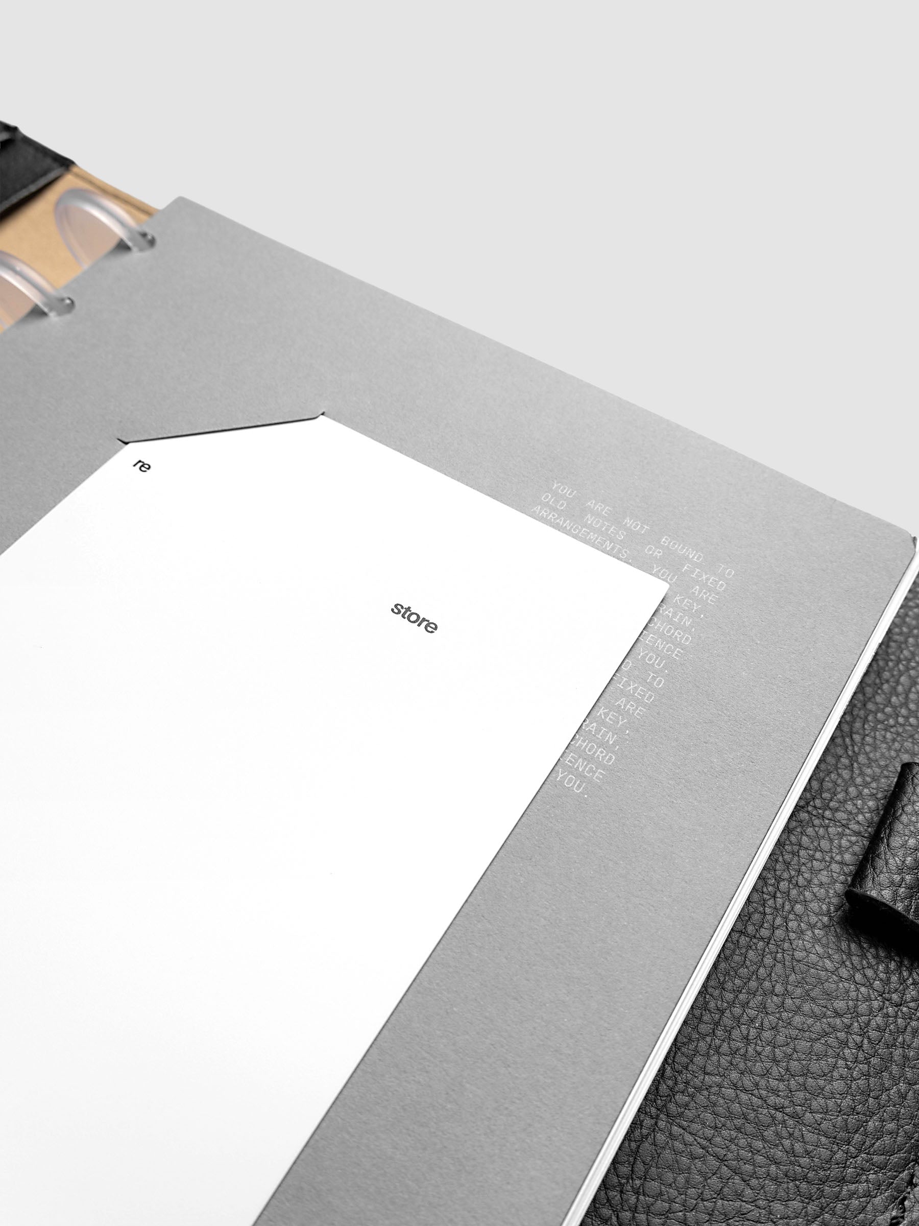 Close up view of a grey cardstock planner dashboard with white plastic card inserted in slits with white printed text.