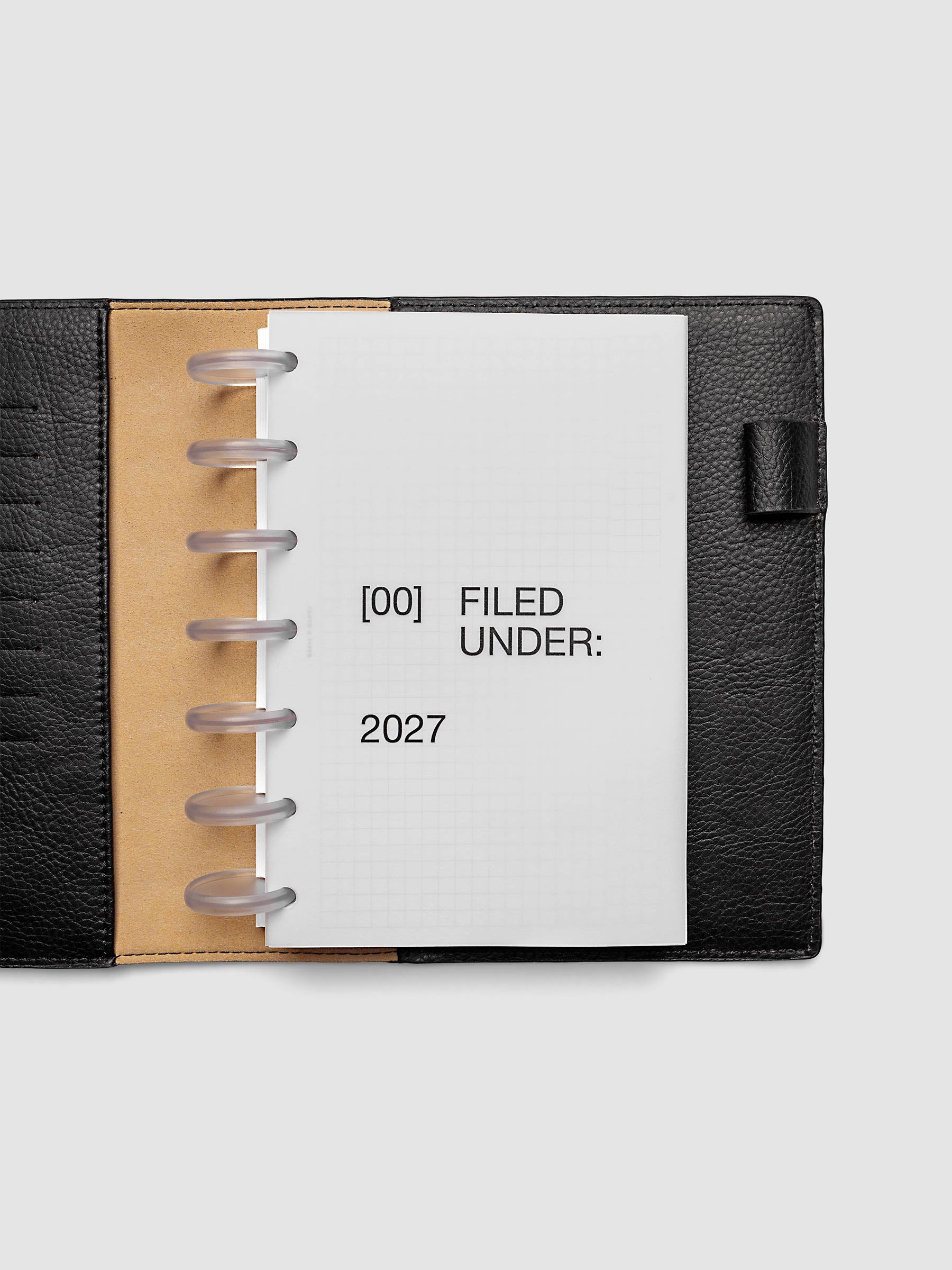 2027 Front + Monthly Dashboard Overlays, Avant Garde, HP Mini 7-Disc Punch, vellum dashboard overlay shown layered inside a planner