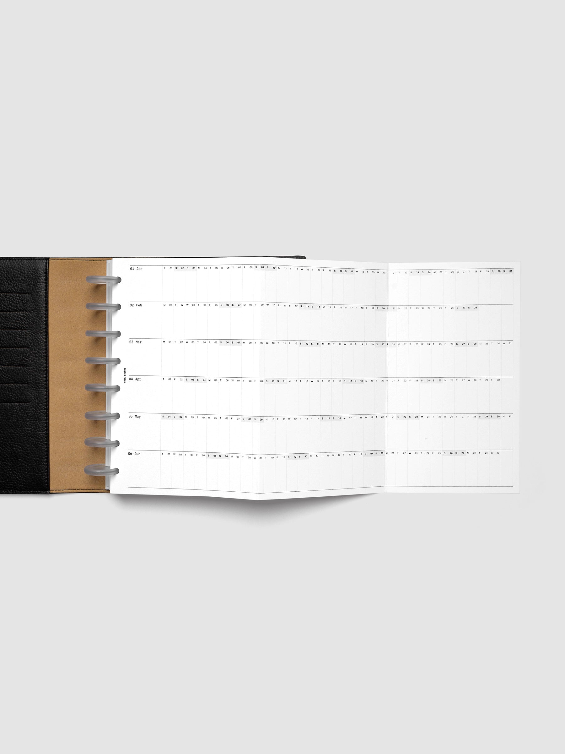 2027 Dated Fold Out Insert fully unfolded inside a Half Letter 8-Disc Punch discbound planner, showing six months of dated calendar boxes across one side.