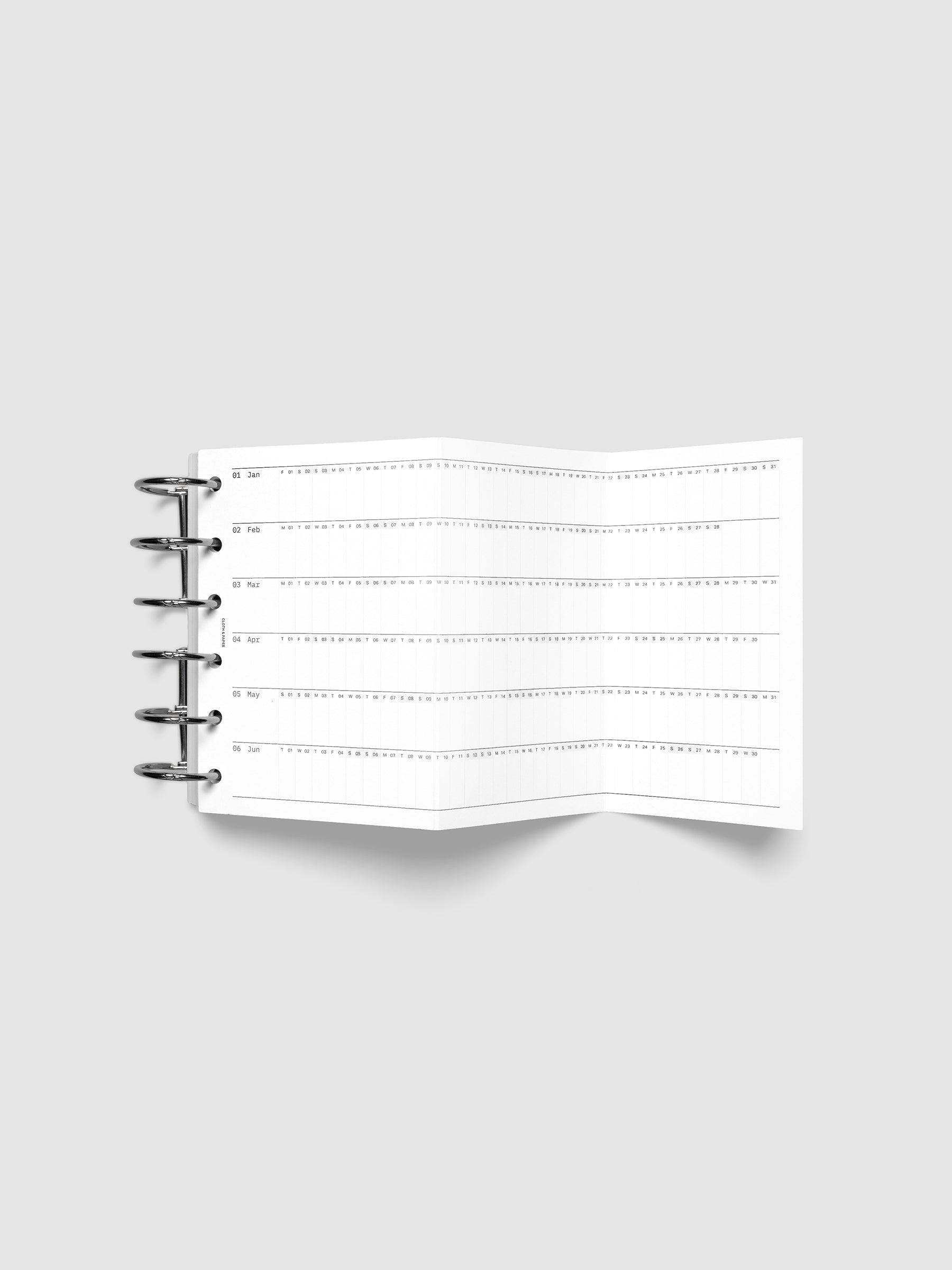 2027 Dated Fold Out Insert fully unfolded inside a Pocket 6-Ring Punch 6-ring planner, showing six months of dated calendar boxes across one side.
