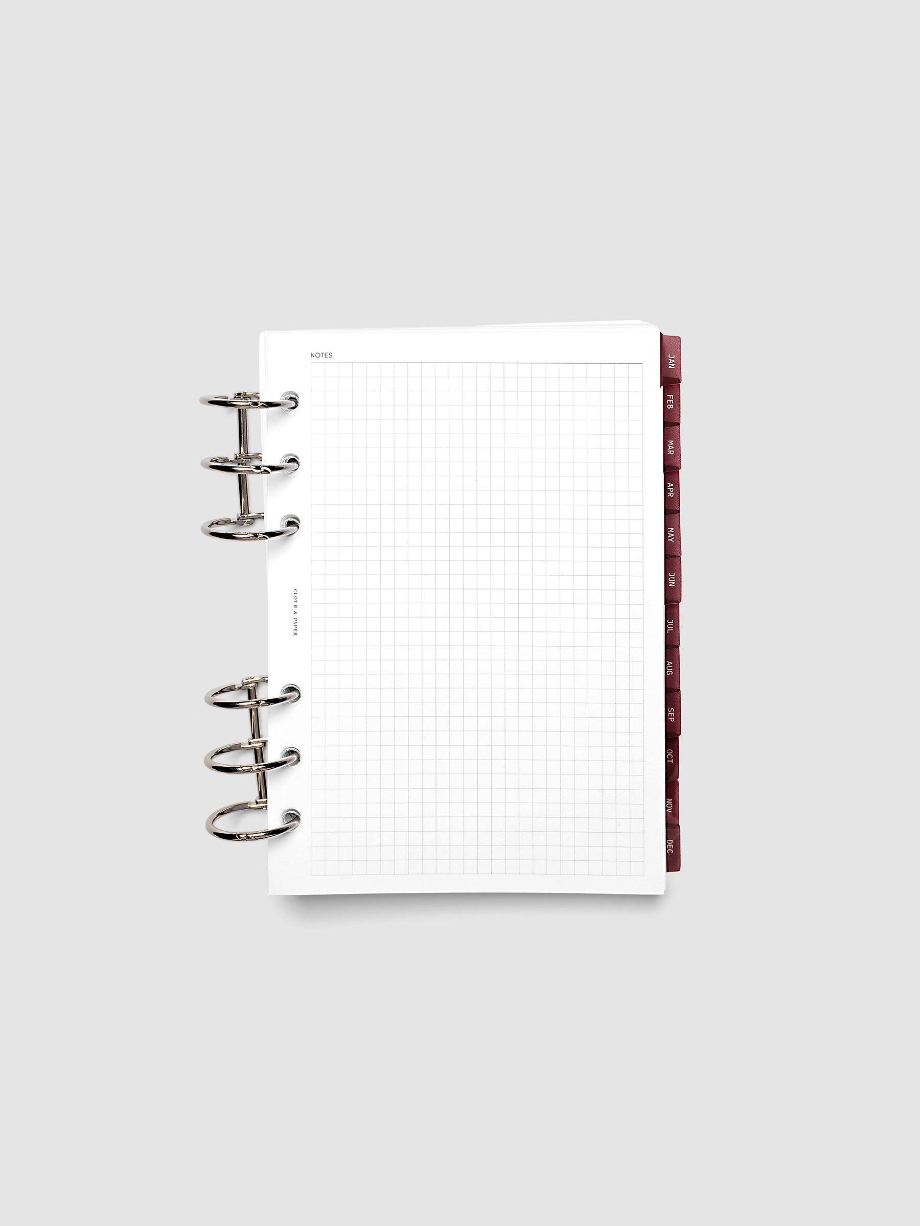 Personal Wide 6-Ring Punch Ultra-Thin Monthly Dividers in deep red shown tabbed inside a planner