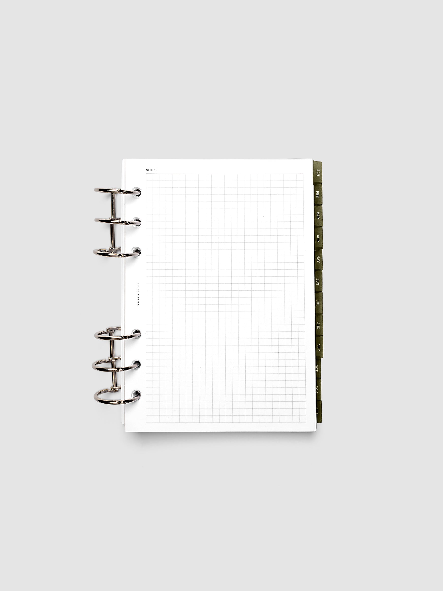 Personal Wide 6-Ring Punch Ultra-Thin Monthly Dividers in olive green shown tabbed inside a planner