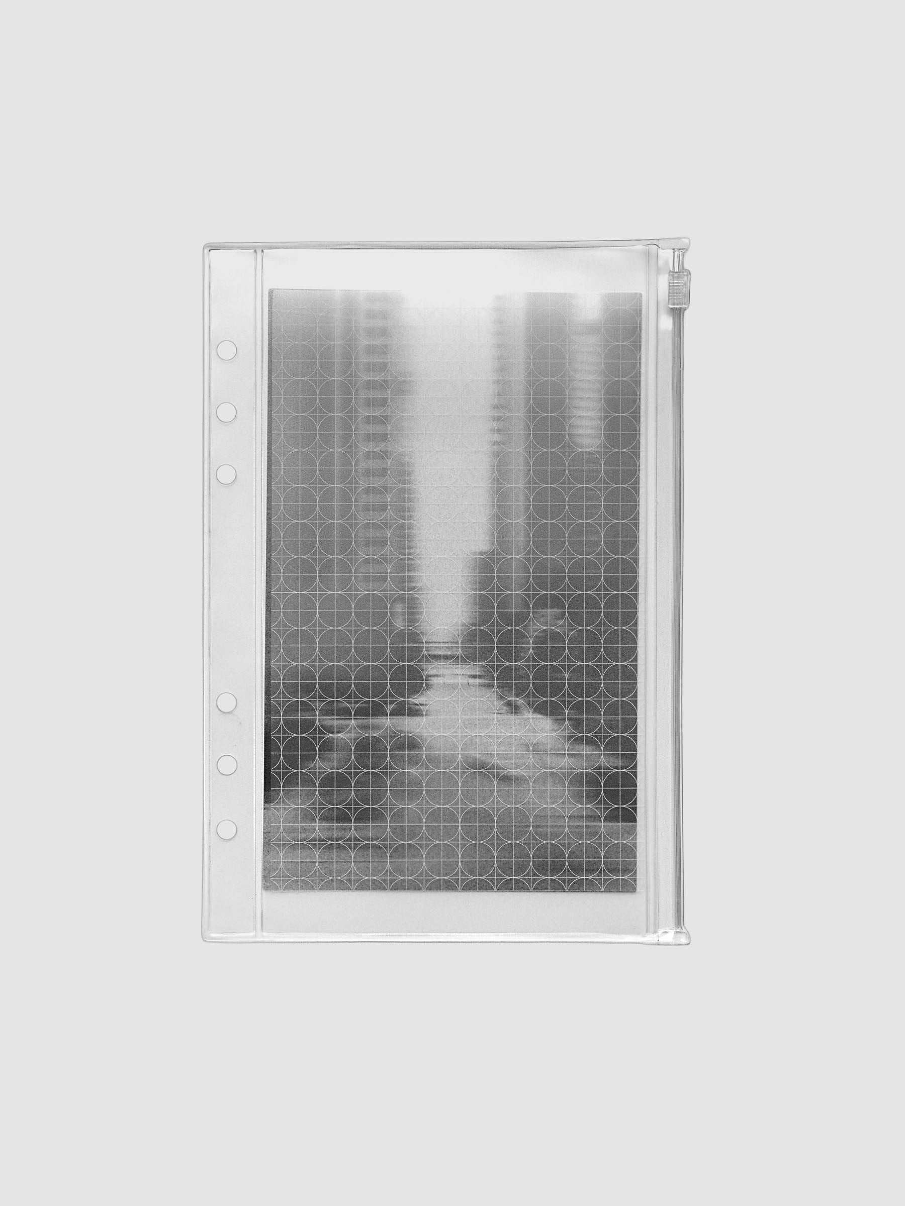 Zippered transparent pouch pre-punched for A5 size ring bound planners and notebooks. Features a graph and a photographic decorative inner insert.