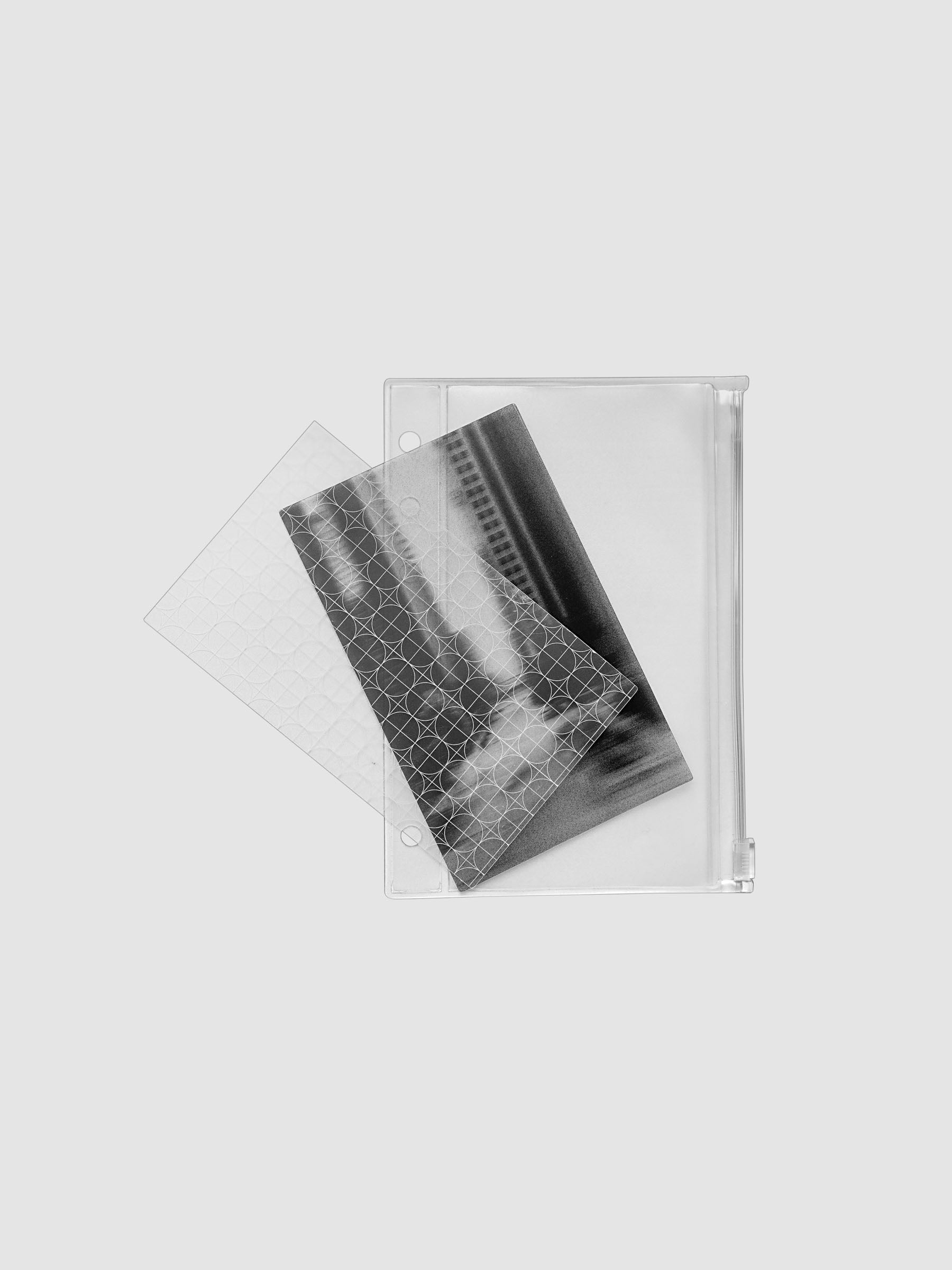 One transparent graph overlay, one black and clear abstract photo overlay, and one clear pre-punched zippered pouch for planners. Shown in size A6.