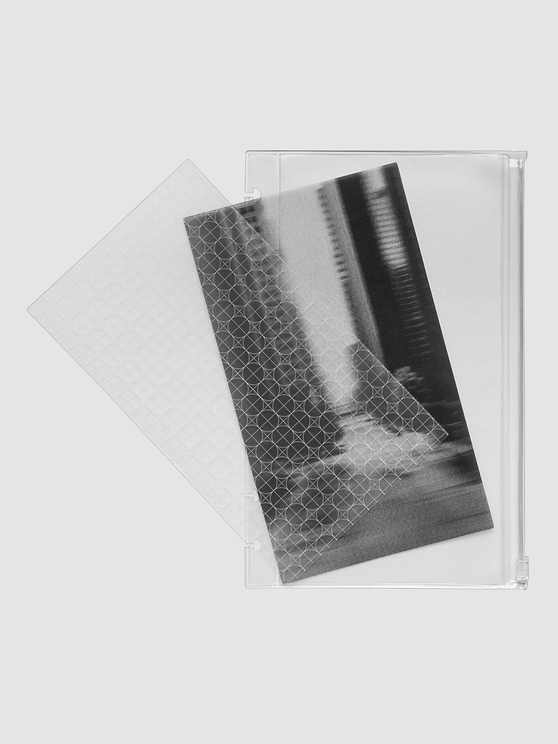 One transparent graph overlay, one black and clear abstract photo overlay, and one clear pre-punched zippered pouch for planners. Shown in size Half Letter.