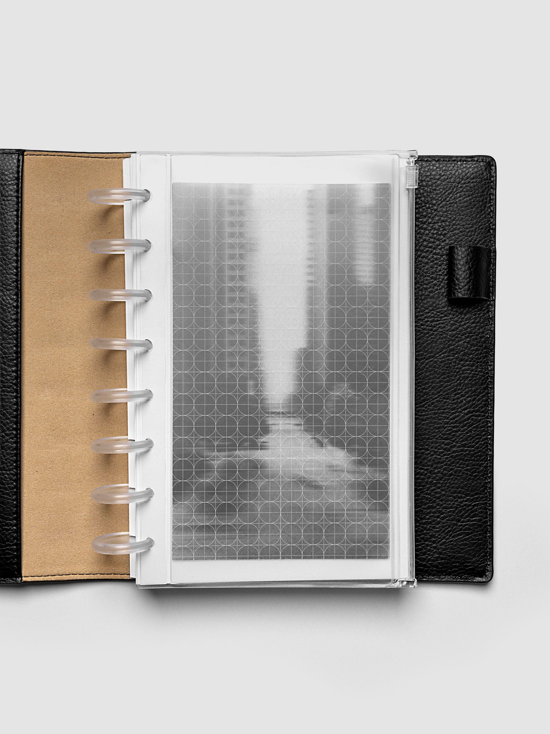 Side zipper transparent storage pouch for planners with decorative inner graph and photograph layers shown in a Half Letter planner folio cover.