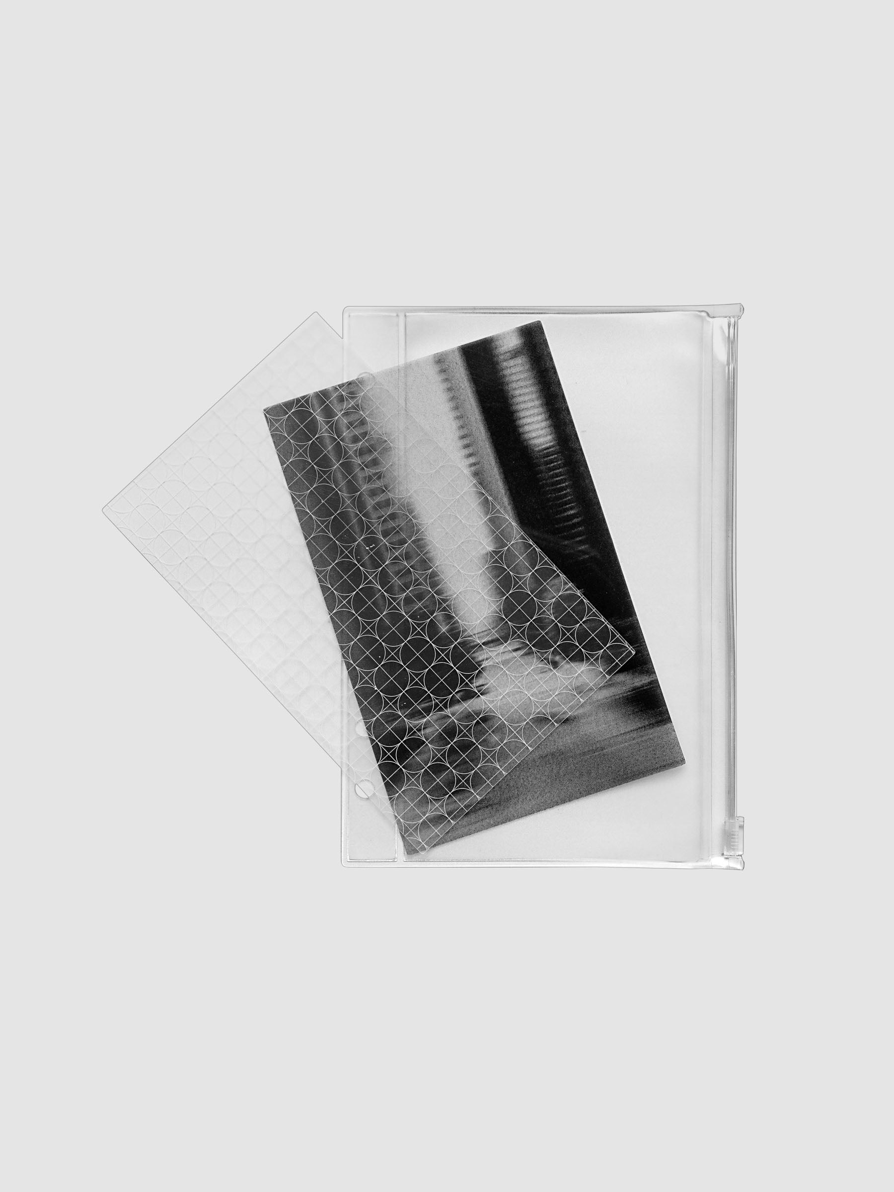 One transparent graph overlay, one black and clear abstract photo overlay, and one clear pre-punched zippered pouch for planners. Shown in size Personal Wide.