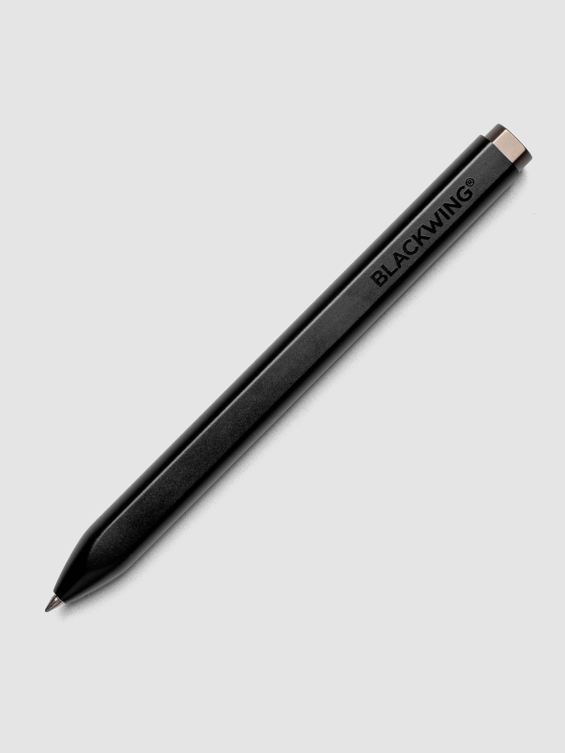 Full product view of the Blackwing pencil in matte black with a flat side on the barrel to prevent rolling.