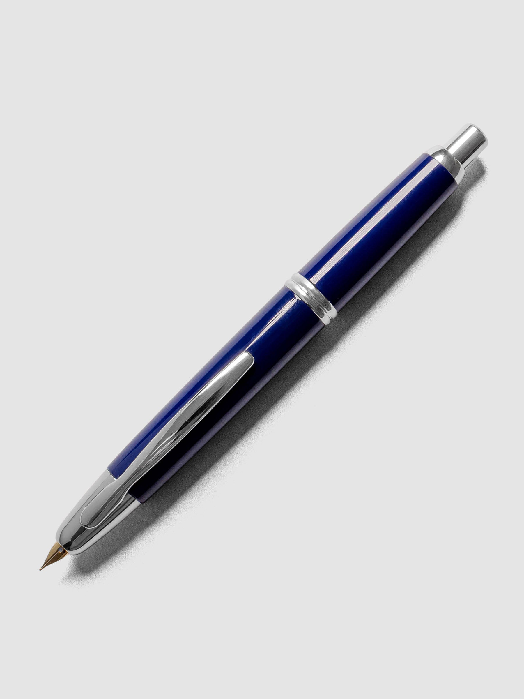 Blue Rhodium Pilot Vanishing Point Fountain Pen with cap on on a neutral background.