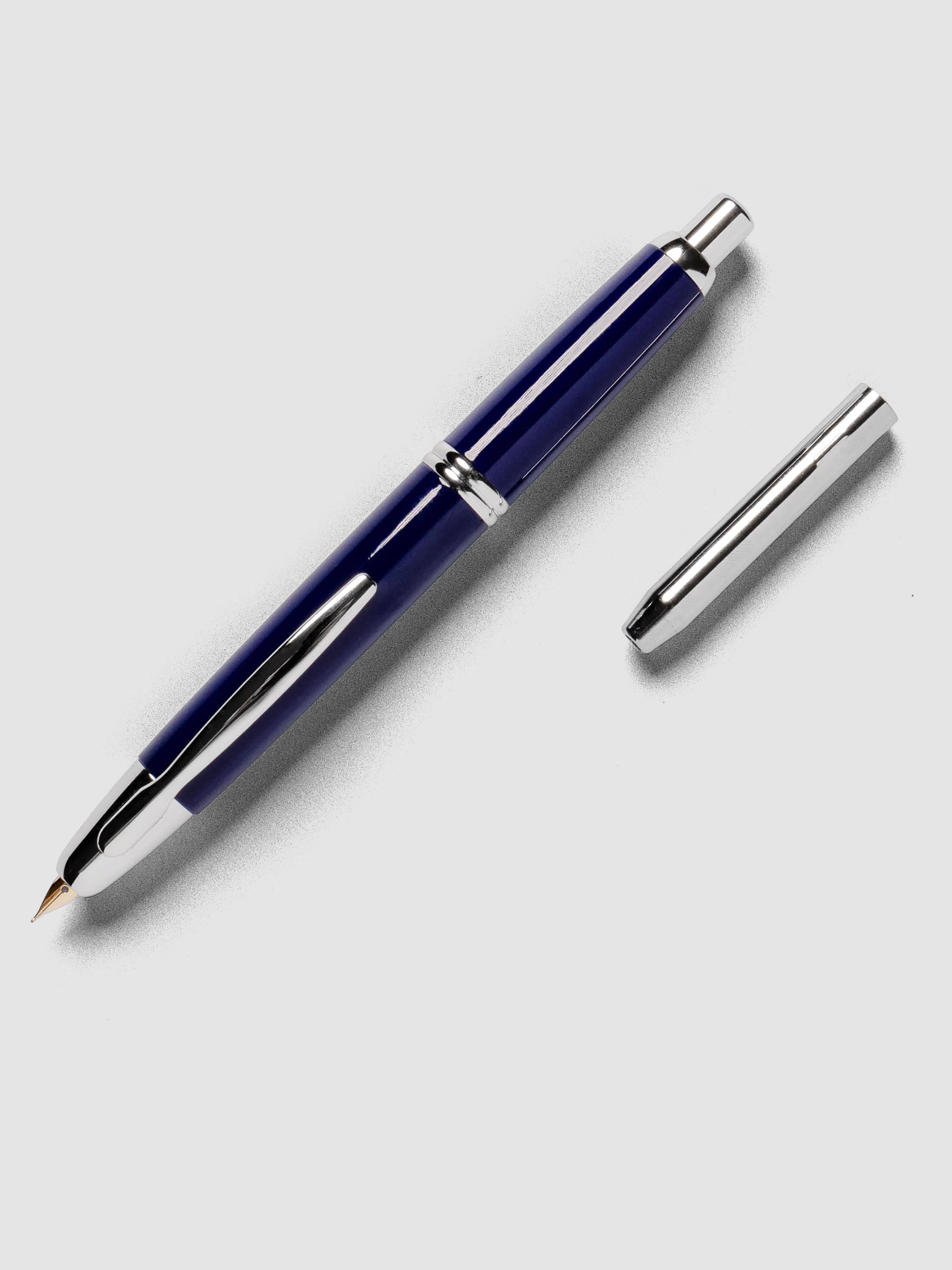 Blue Rhodium Pilot Vanishing Point Fountain Pen with cap off on a neutral background.