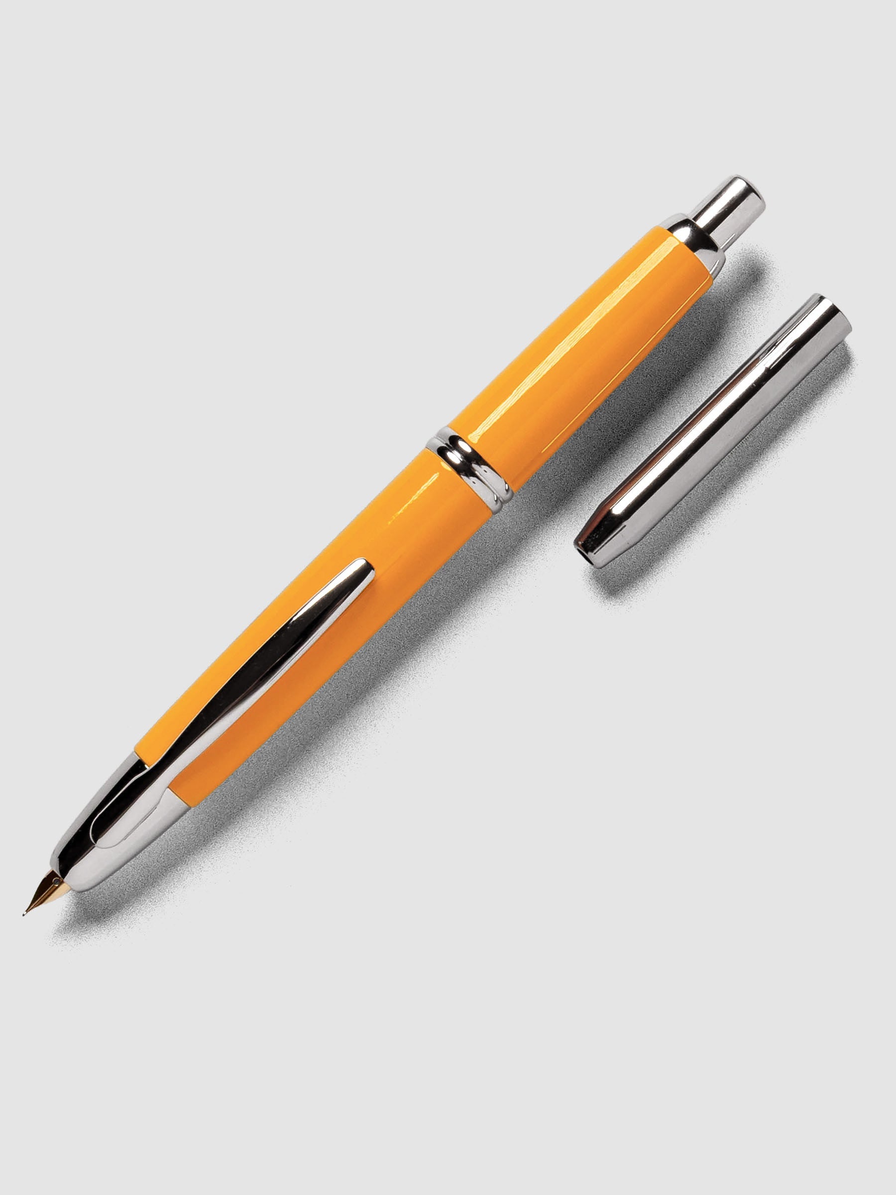 Yellow Rhodium Pilot Vanishing Point Fountain Pen with cap off on a neutral background.