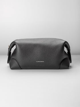 Folded Form Pouch in black pebbled leather, front view, snapped closed with silver foil Cloth & Paper logo centered on exterior
