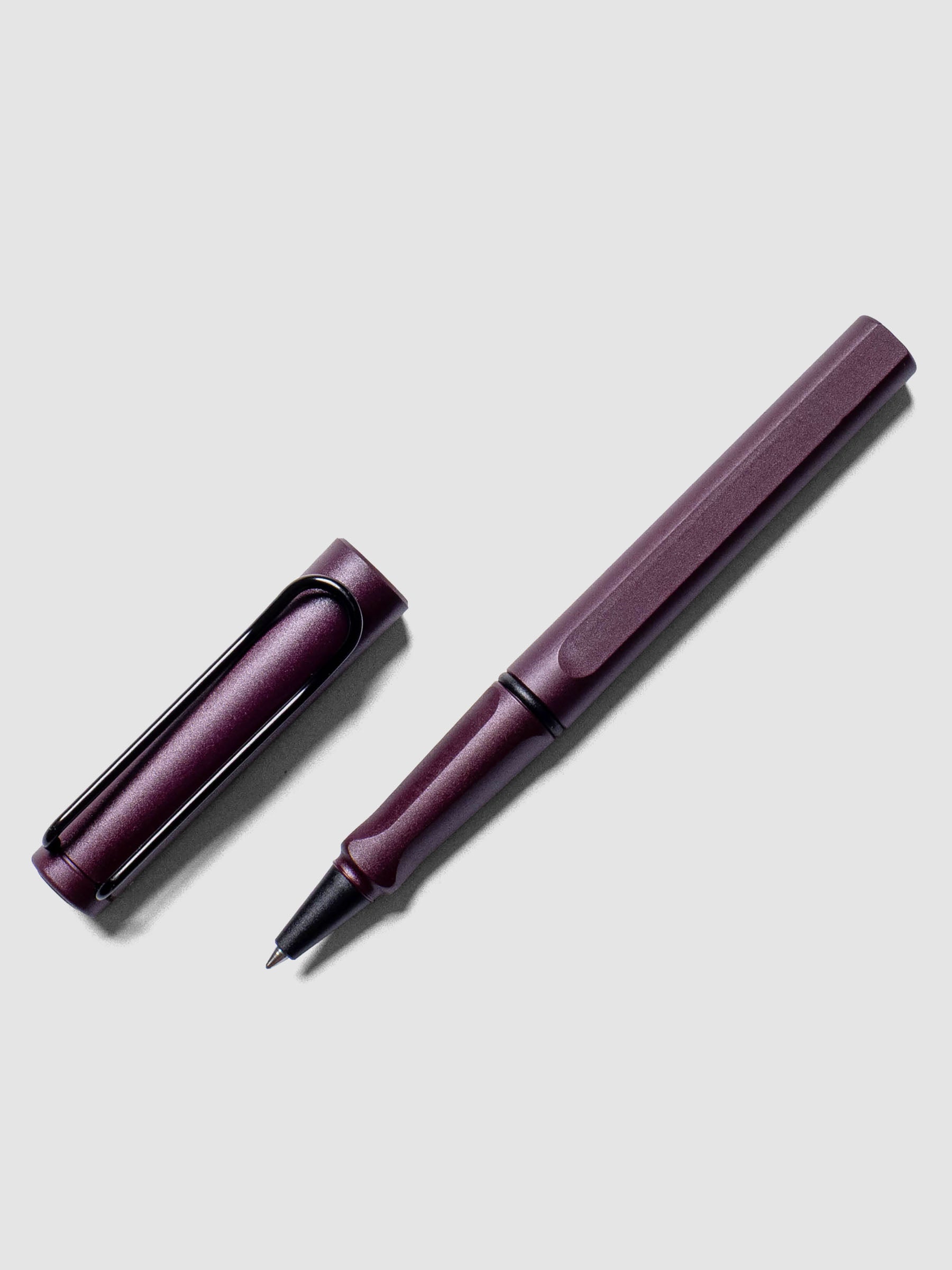 LAMY Safari Rollerball Pen | Scarlett | 0.7 mm shown at an angle on a neutral background. Cap is removed from the pen and placed beside the body.