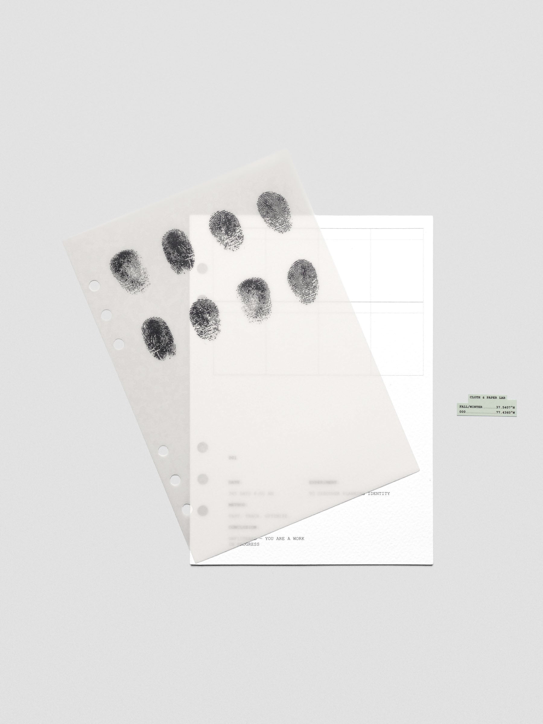 Two layered A5 sized planner dashboards, one semi-transparent, one matte, featuring a fingerprint design shown offset from one another.