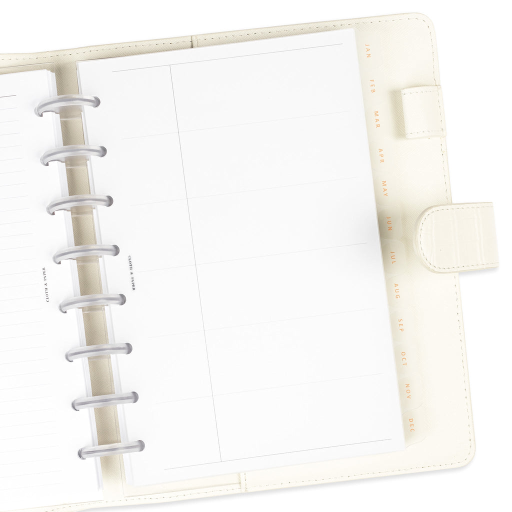 Dividers in use in a discbound planner placed inside of a white leather folio agenda.