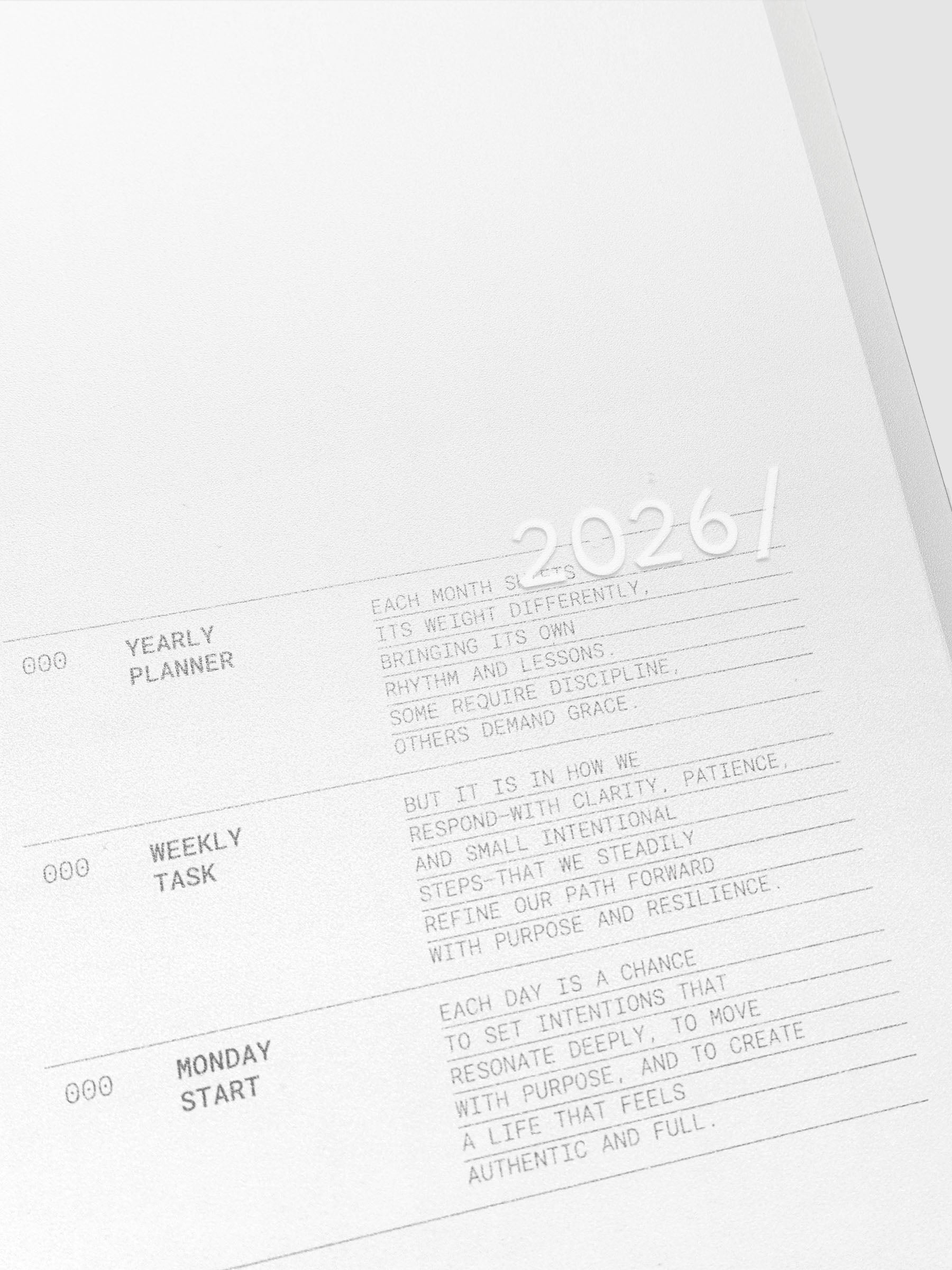 Close up of the 2026 Weekly Task Notebook cover with 2026 printed in white on the front. The transparent cover shows the page below with a description of the planner.